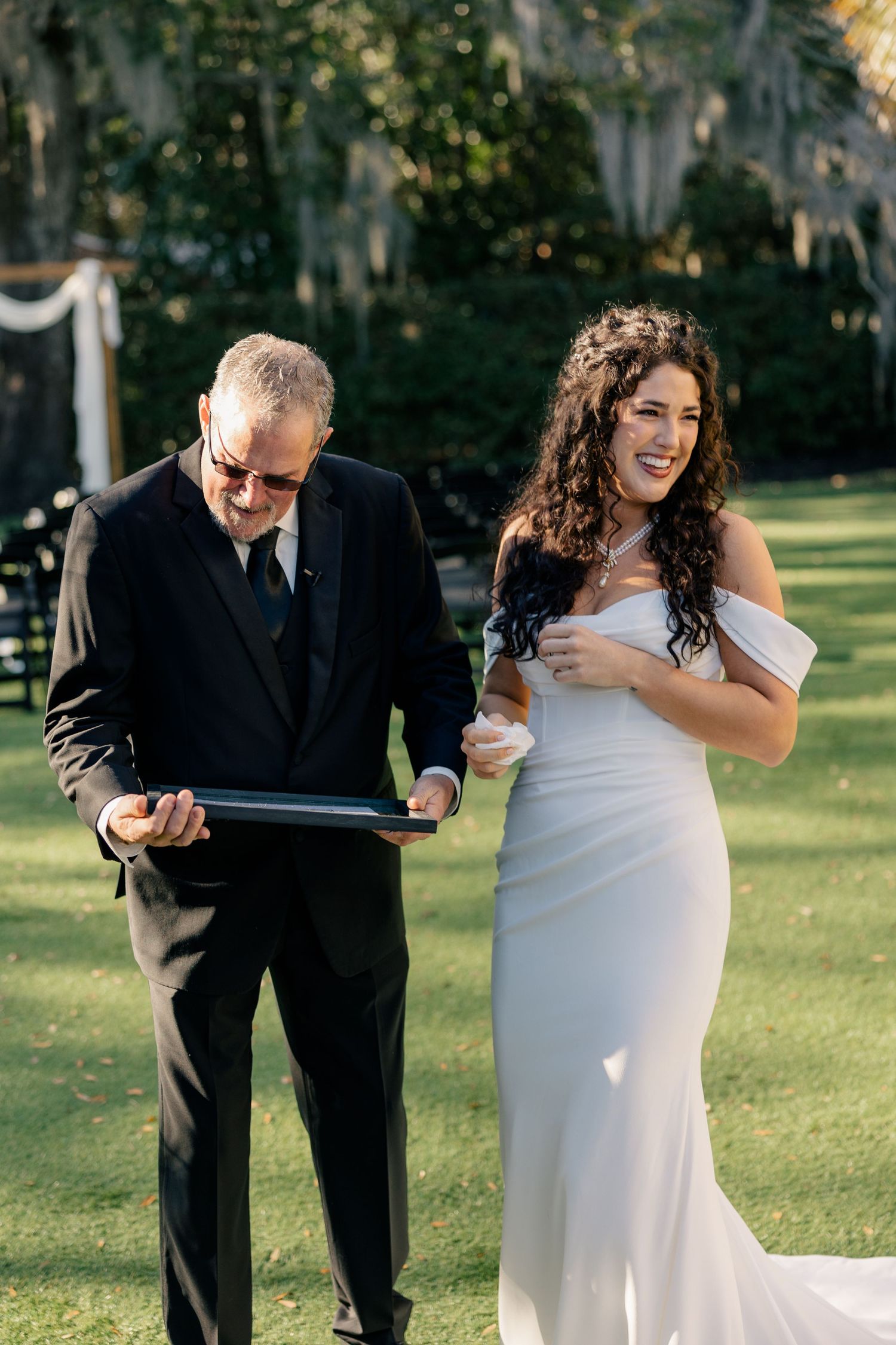 A couple sharing a joyful moment during an outdoor wedding ceremony.