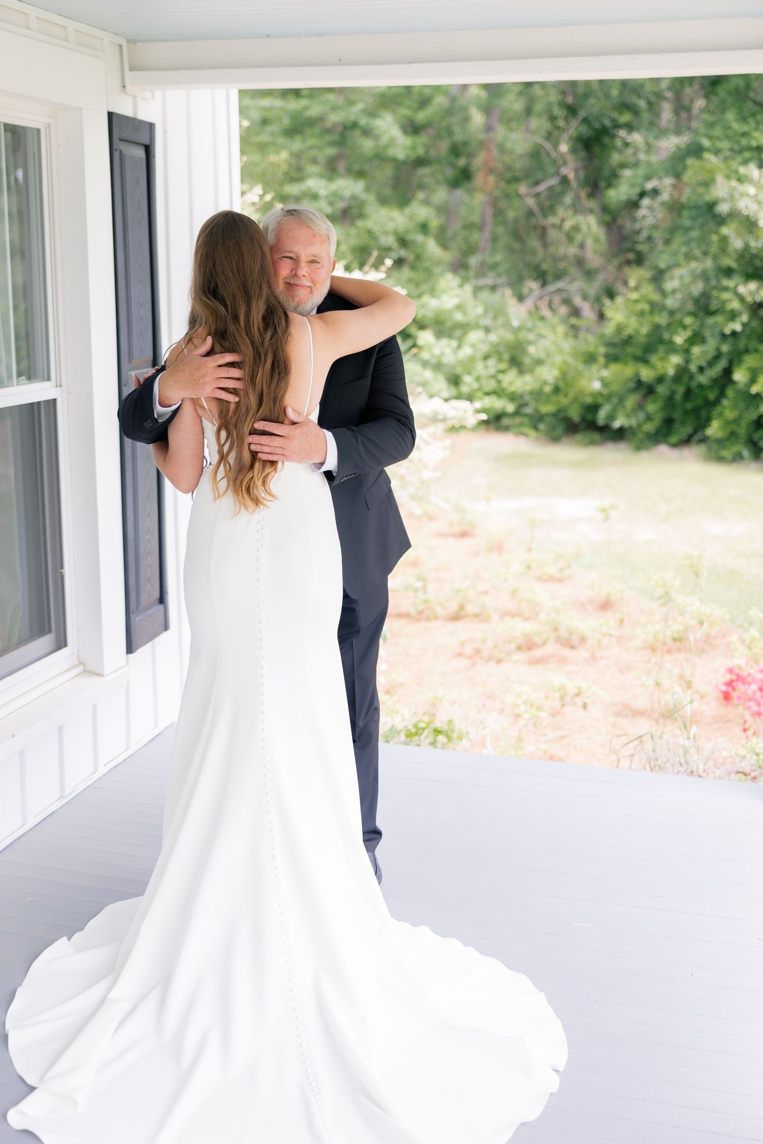 First look moment between couple on a white porch with flowing wedding dress.