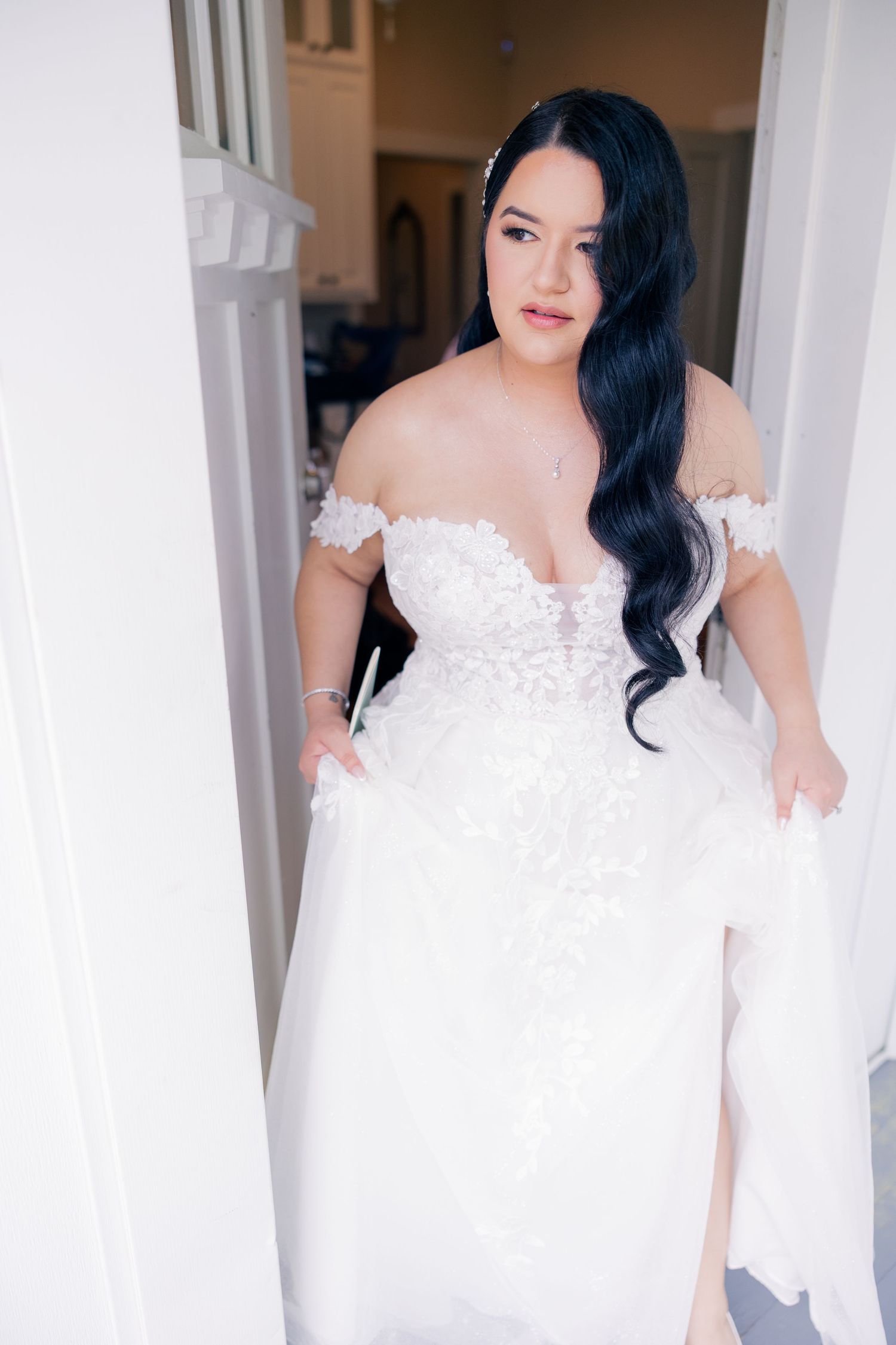 An elegant off-shoulder white lace wedding gown on display.