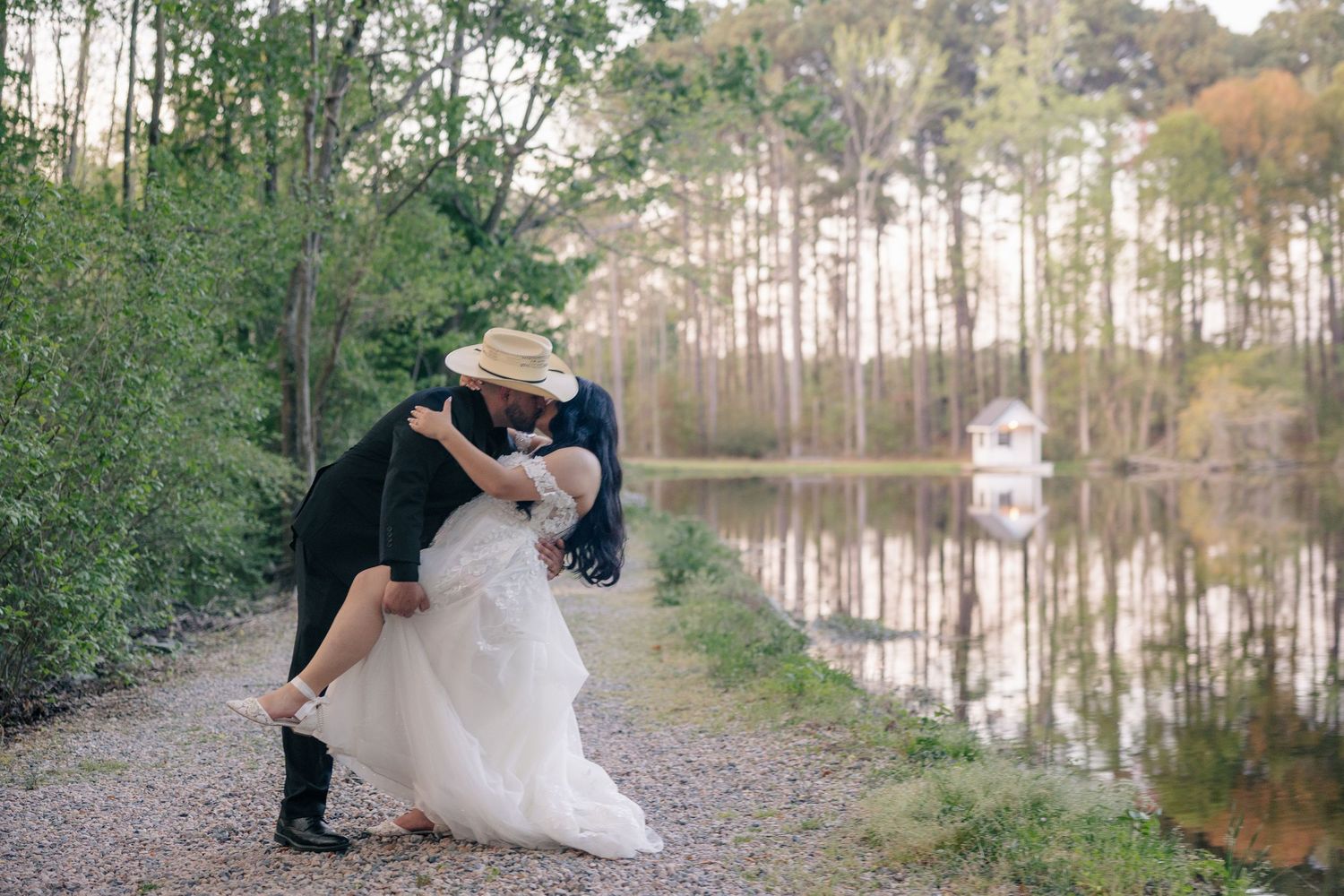 Romantic wedding portraits captured by a serene lake with pine trees in the background.