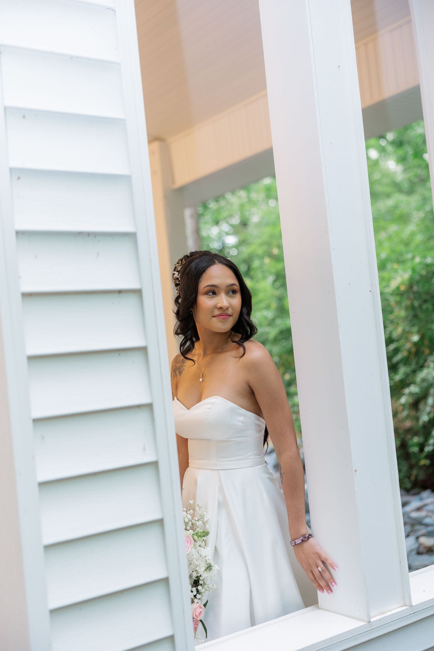 Elegant wedding portrait captured between white columns of a classic Southern porch.