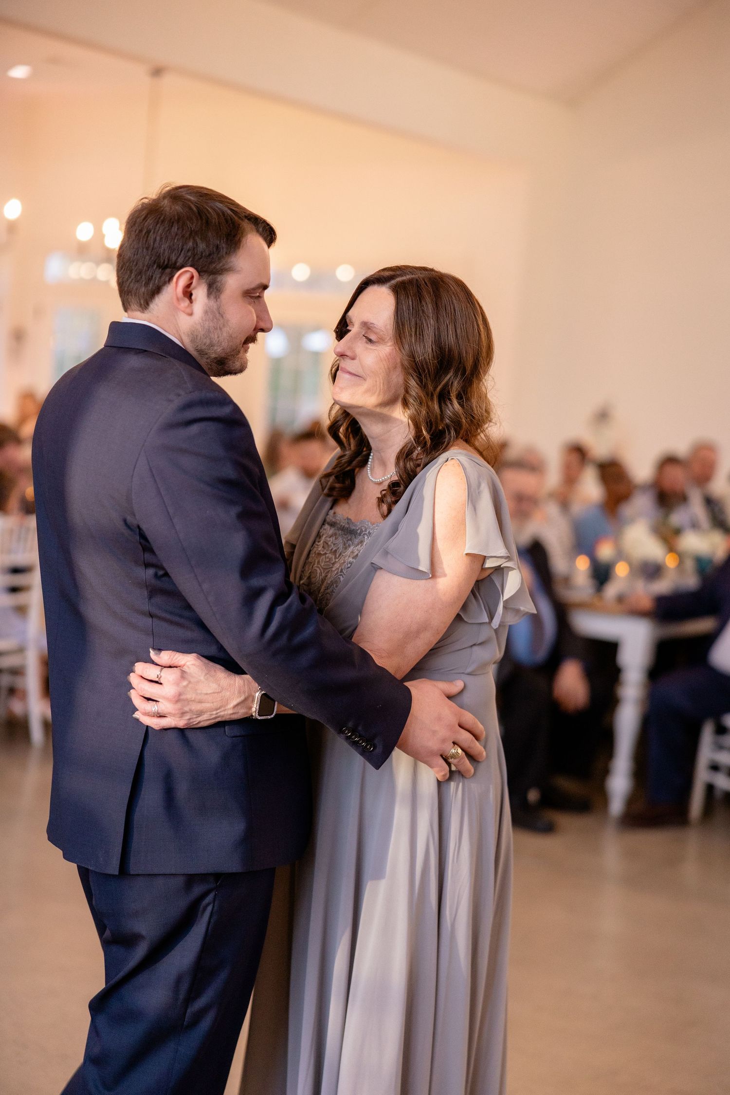 Couple shares an intimate dance moment in formal attire at wedding reception.