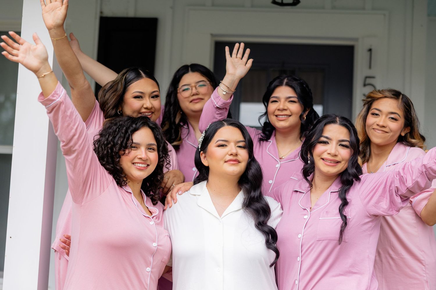 Group wearing matching pink robes celebrating together indoors.
