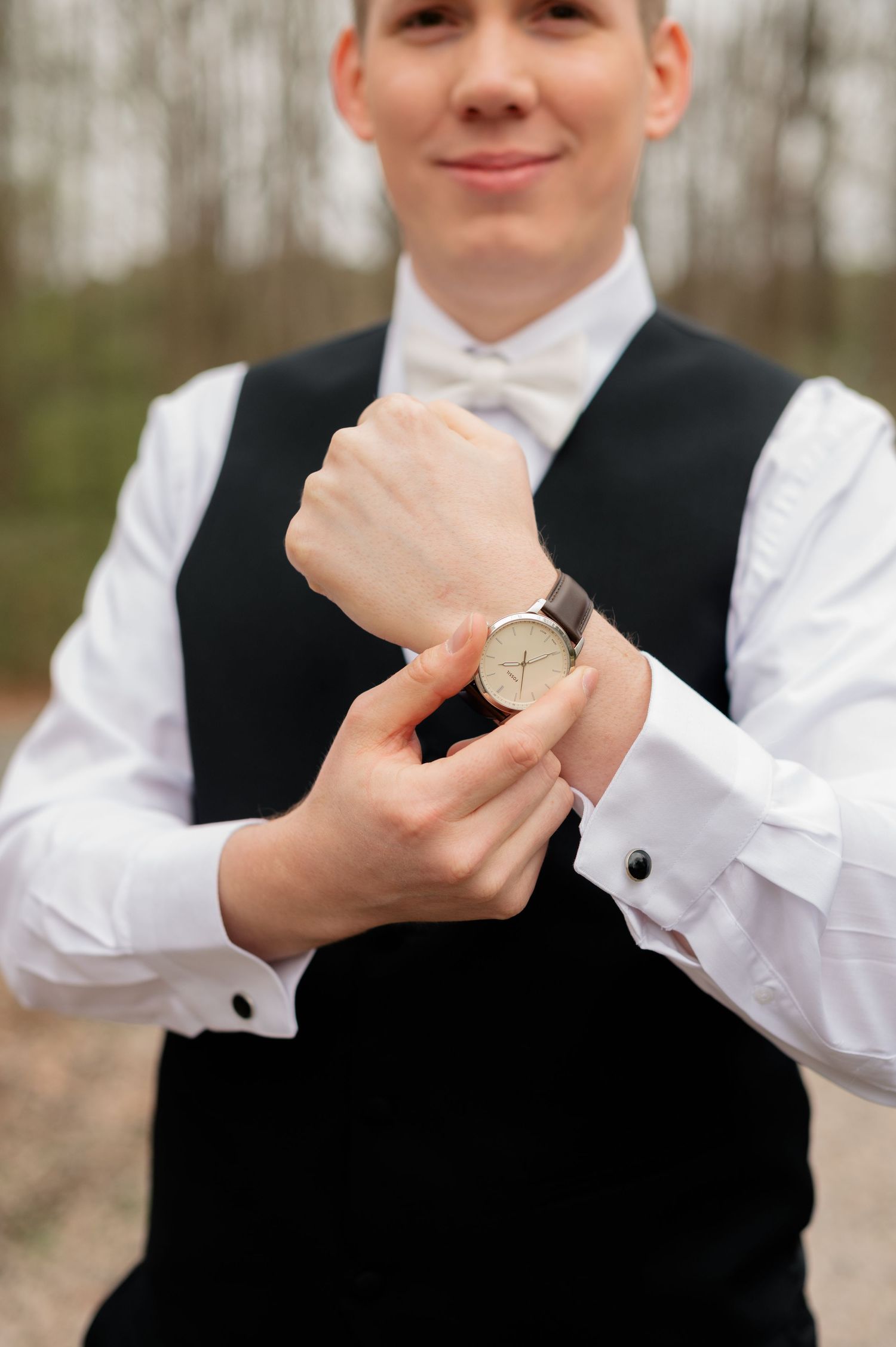 Close-up progression of someone buttoning the sleeve cuff on a formal white dress shirt with cufflinks.