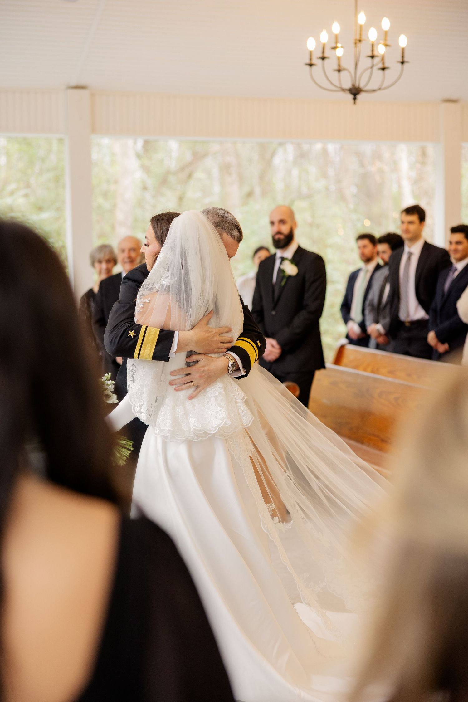 An intimate wedding ceremony moment captured in a bright chapel setting.