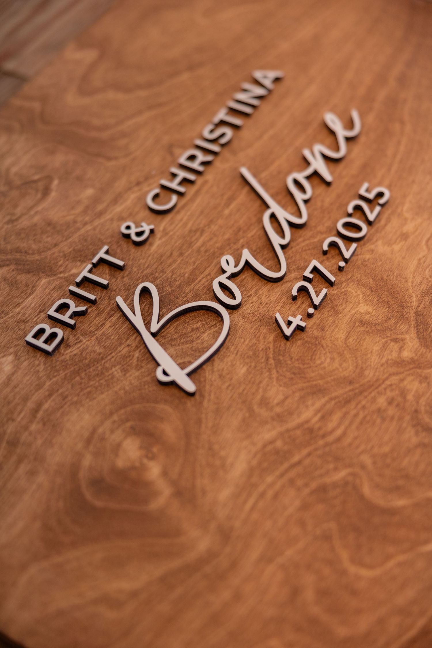 Close-up of wedding date engraved in stylish text on wooden surface.