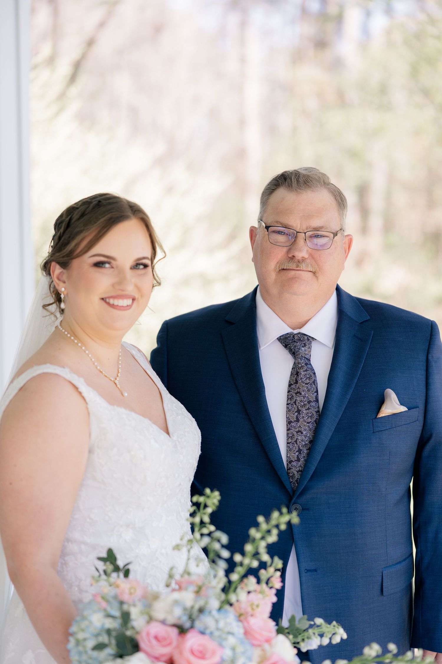 A tender portrait of a bride with her dad on her wedding day, both wearing formal attire.