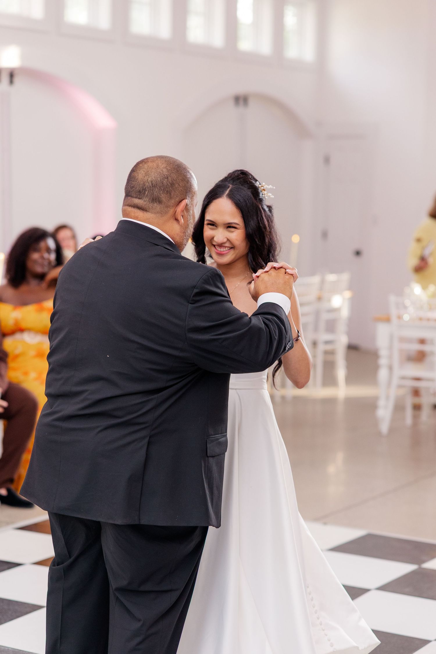 Special dance moment during wedding reception on checkered floor.