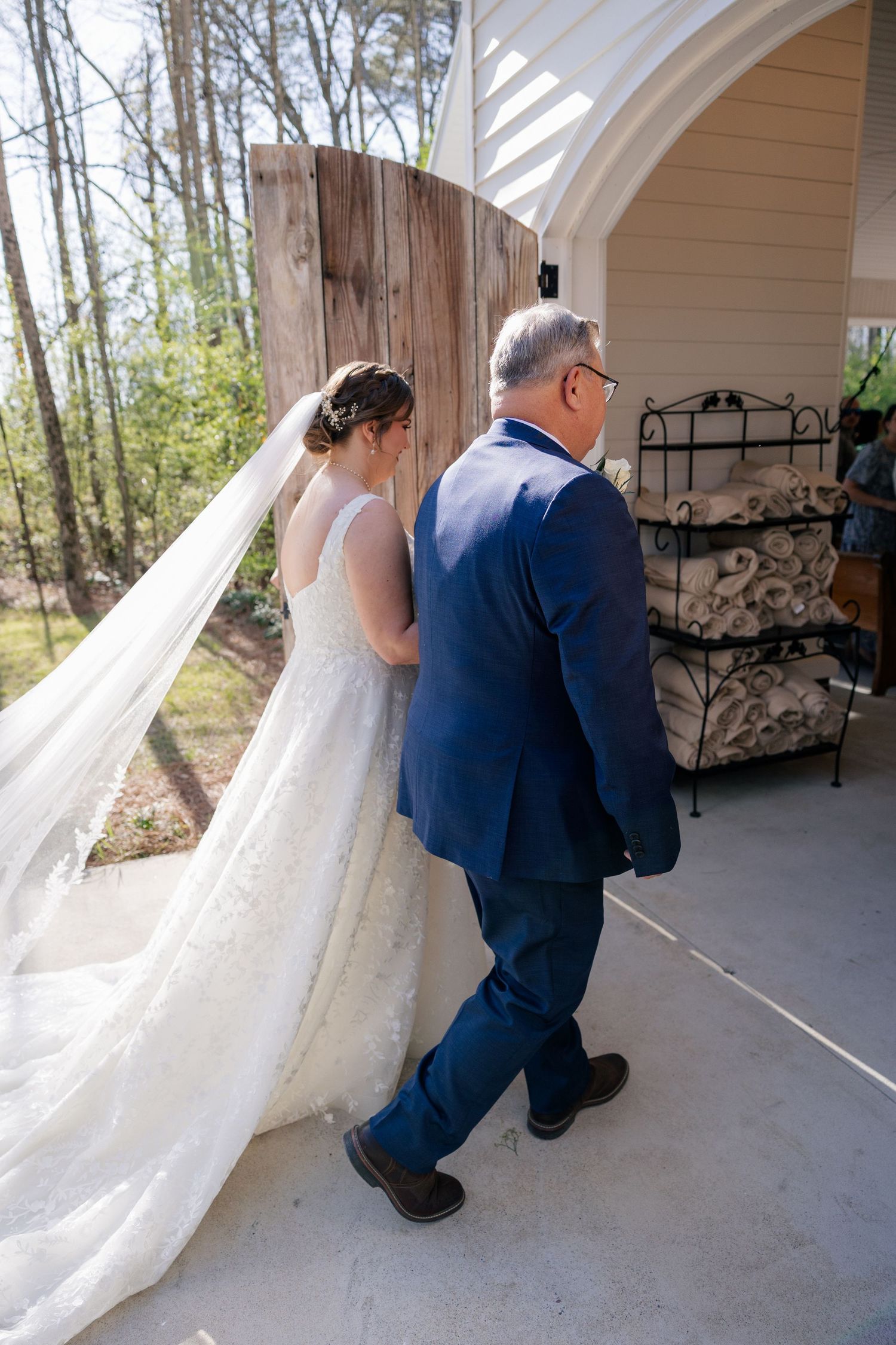 Wedding couple standing together on outdoor covered porch.