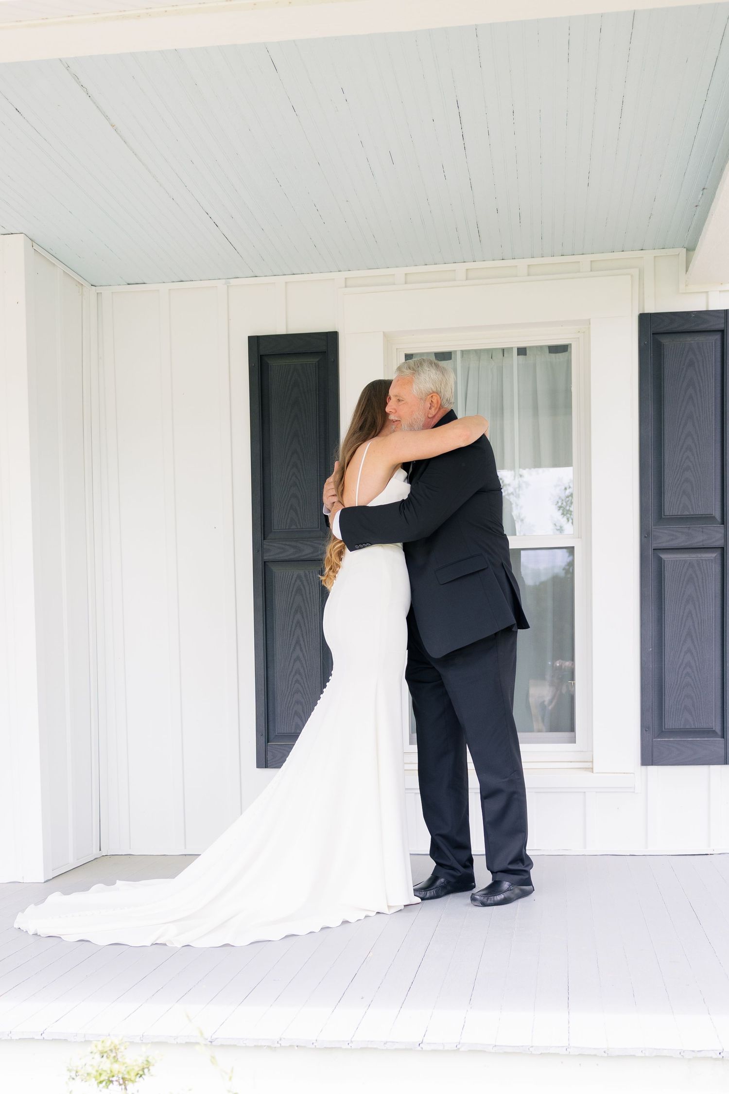 Intimate wedding moments captured on a classic white porch with black shutters.