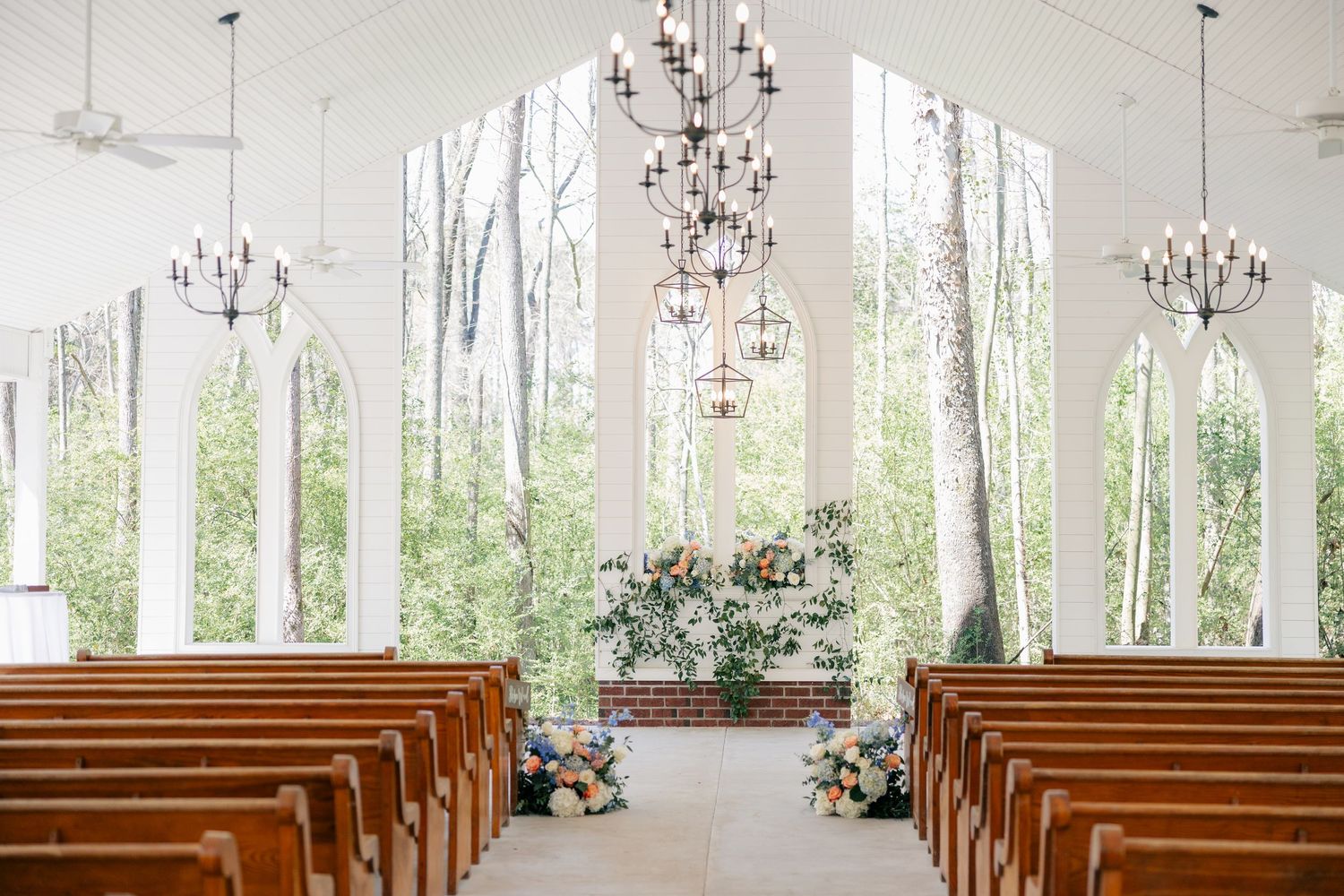 Elegant chapel sanctuary with natural light streaming through windows and crystal chandeliers.