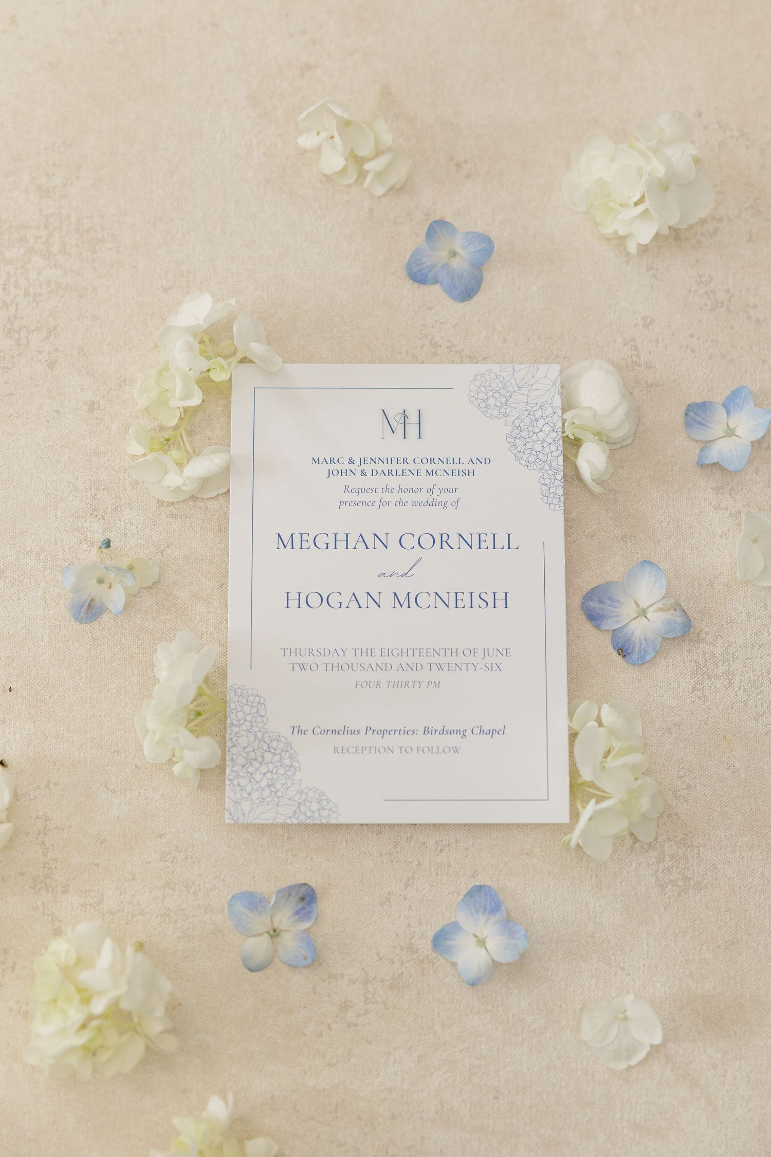 Elegant wedding invitation for Meghan Cornell and Hogan McNeish surrounded by hydrangeas.