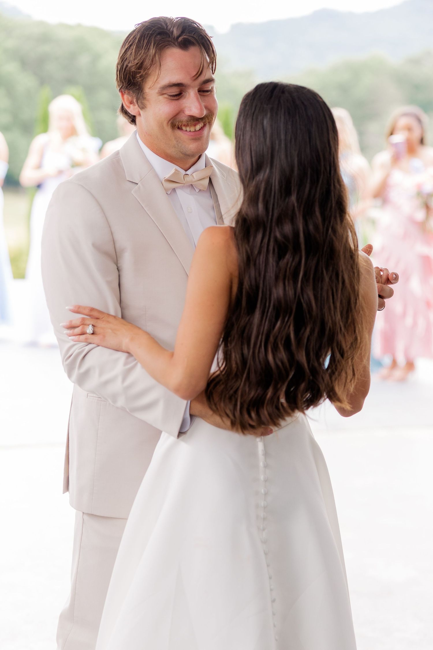 Wedding couple sharing joyful moment during outdoor celebration.