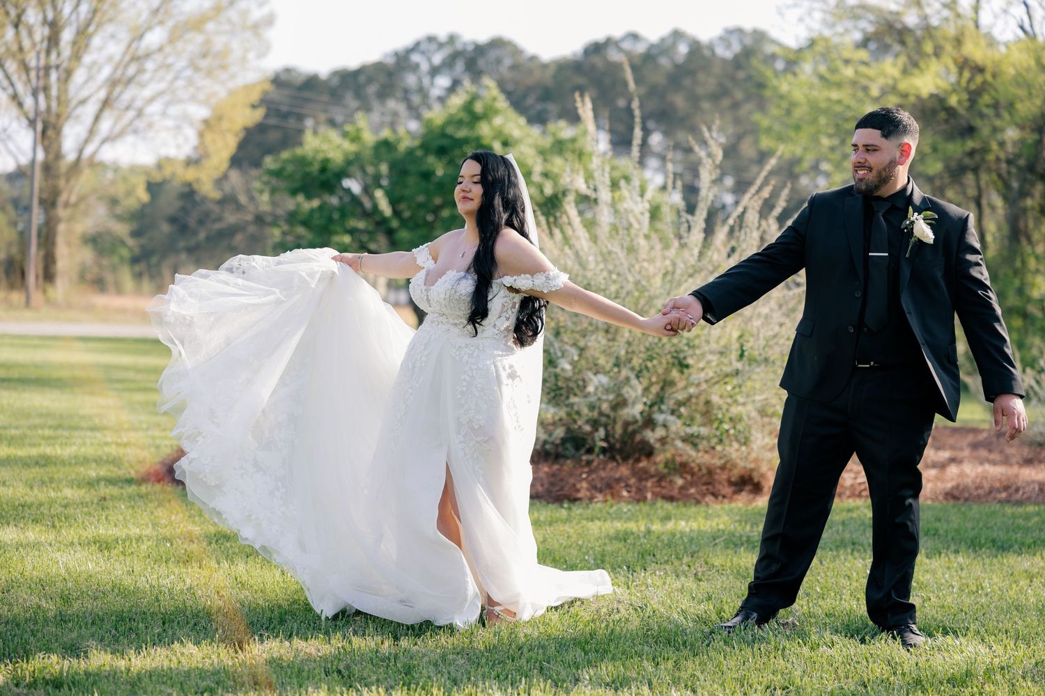 A romantic wedding photoshoot with couple dancing outdoors in a garden setting.