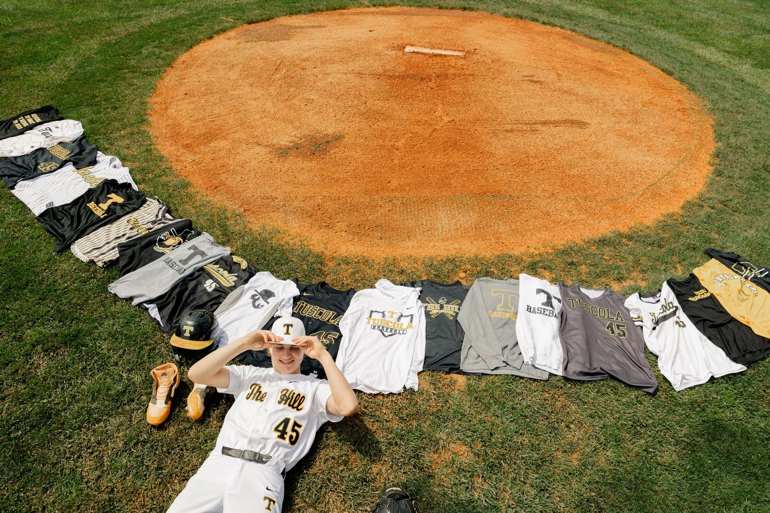 Baseball field crew members lay down and form letters on a dirt infield during a stadium maintenance break.