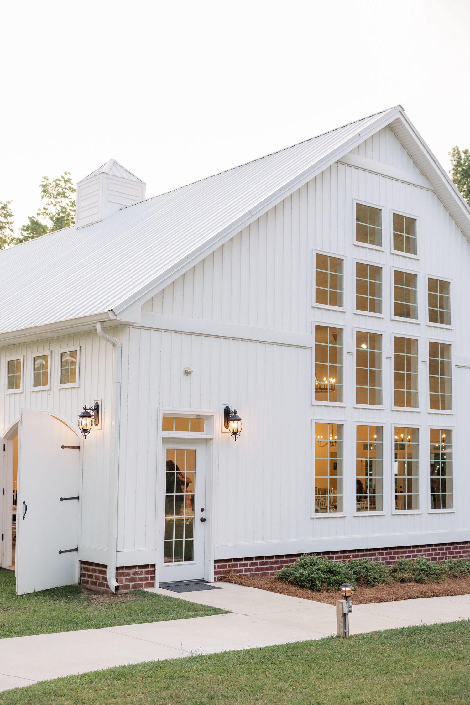 Modern white wedding venue with large windows and classic architectural details.