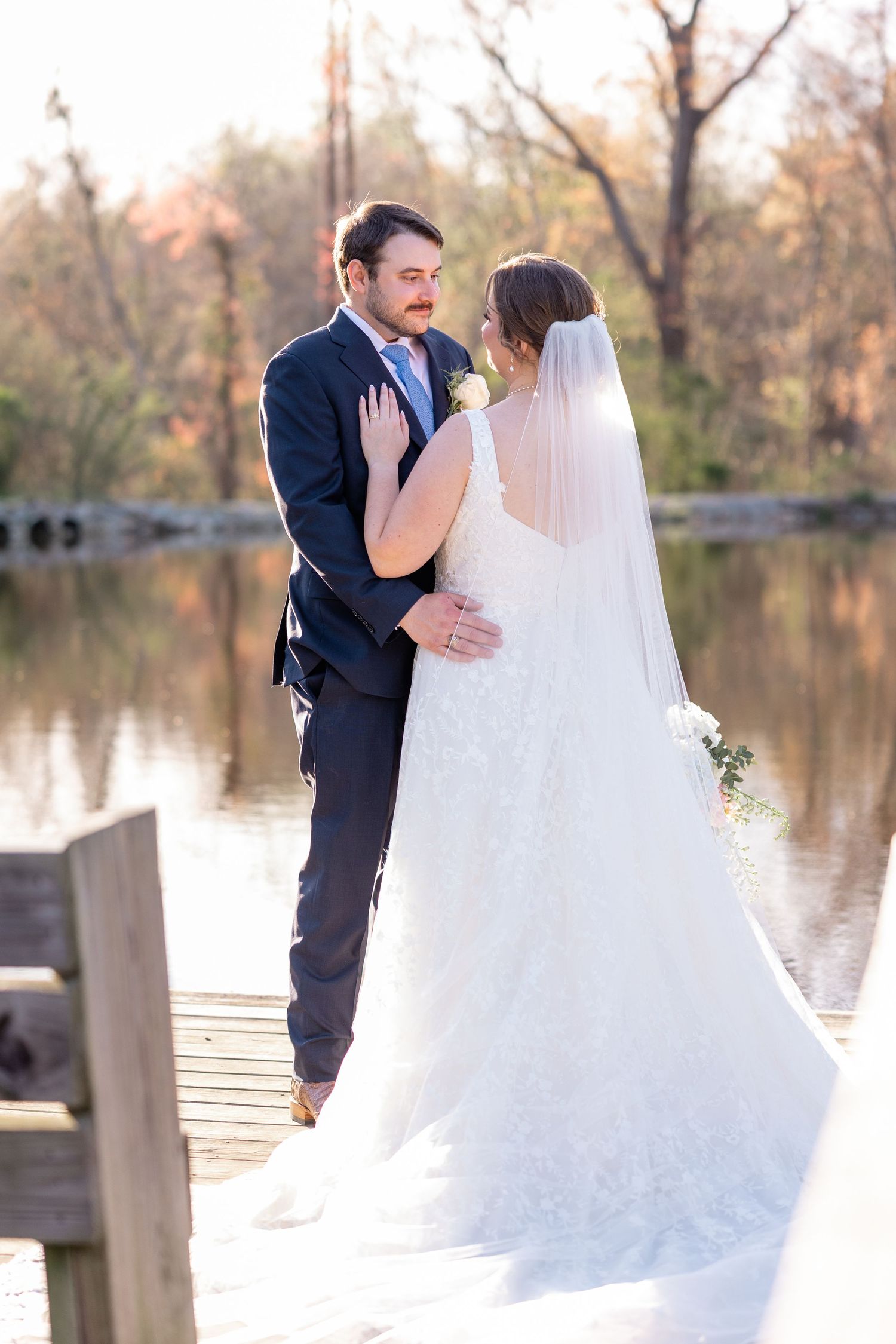 Romantic waterside wedding photos on a dock with flowing white dress.