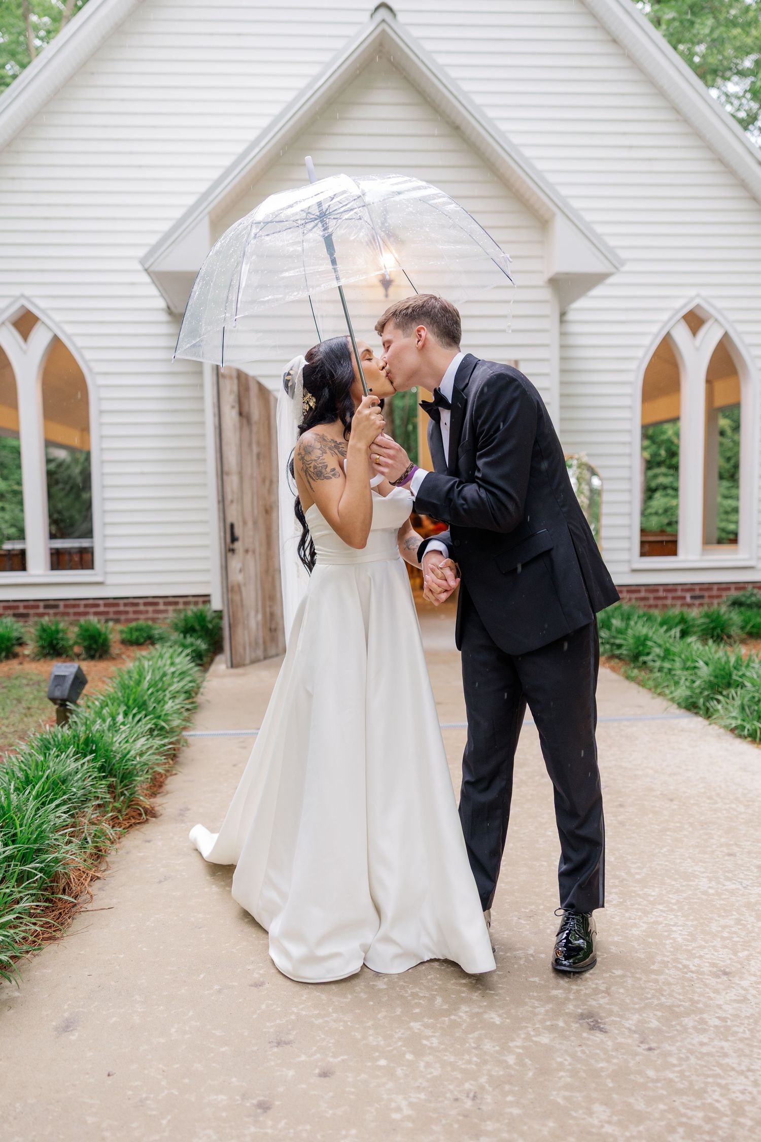 Romantic wedding photography outside a white chapel with elegant architectural details.