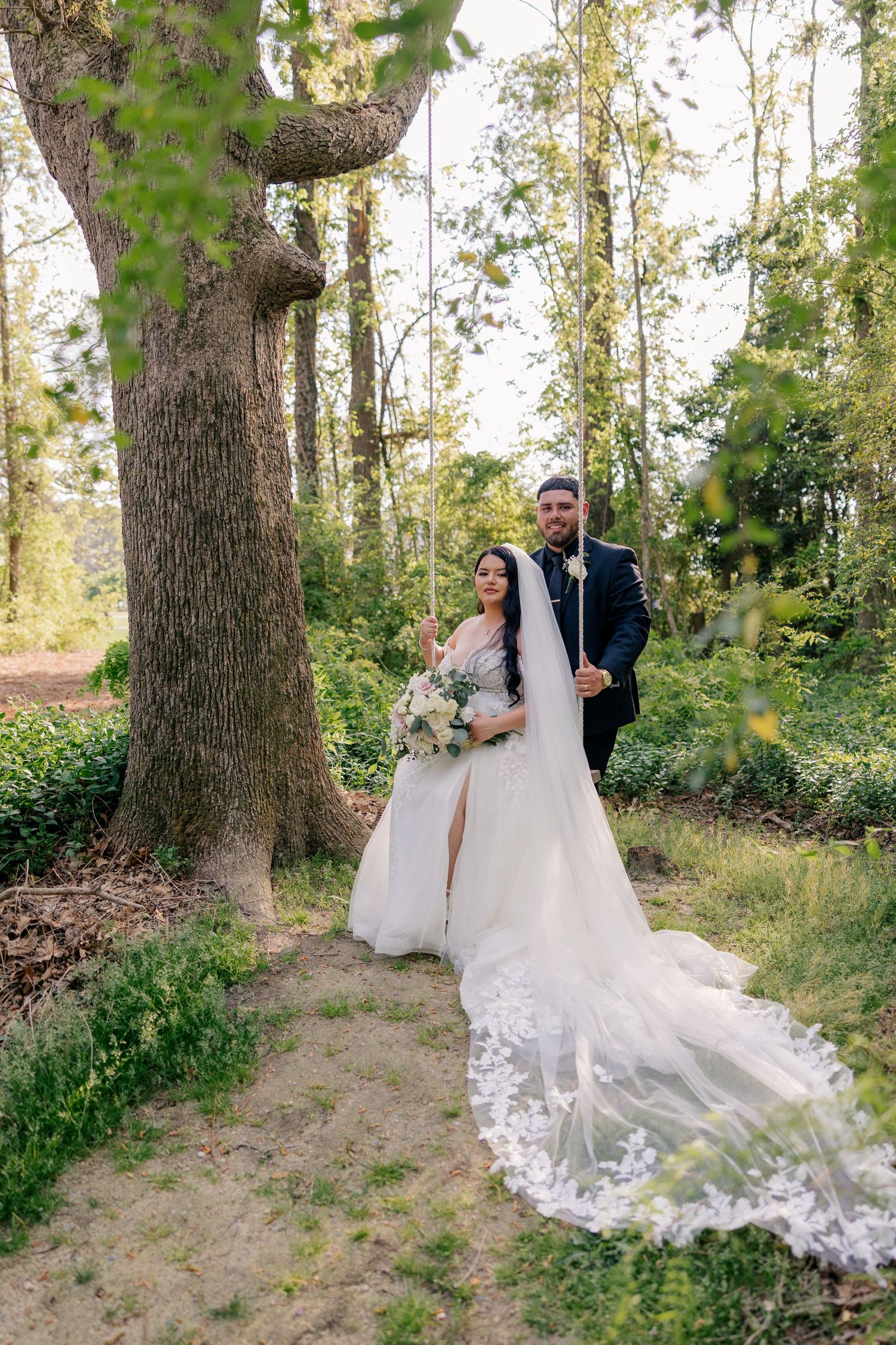 Romantic wedding photos taken in a wooded setting with sunlight filtering through the trees.