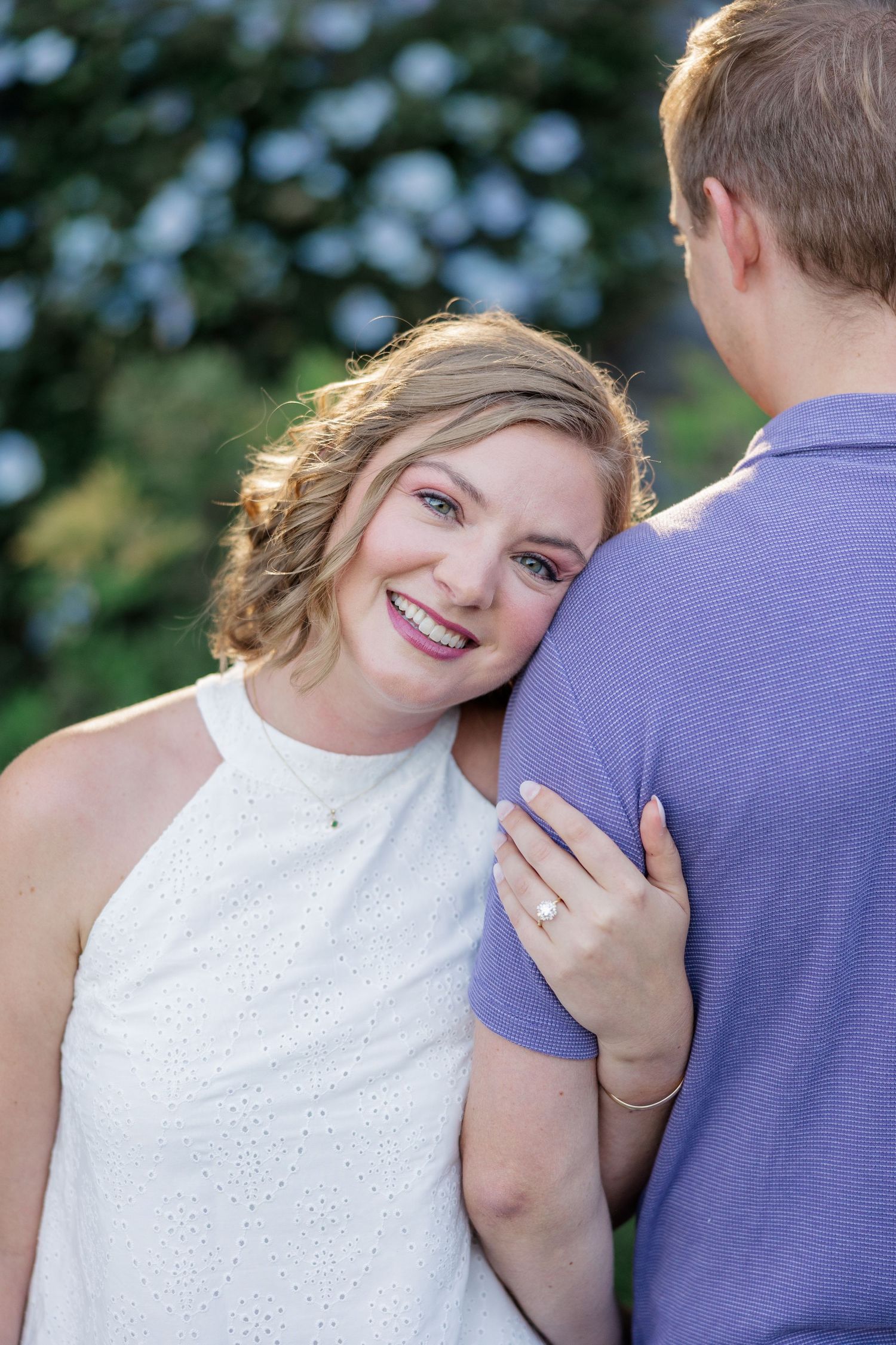 A romantic moment captured outdoors with natural lighting and genuine laughter.