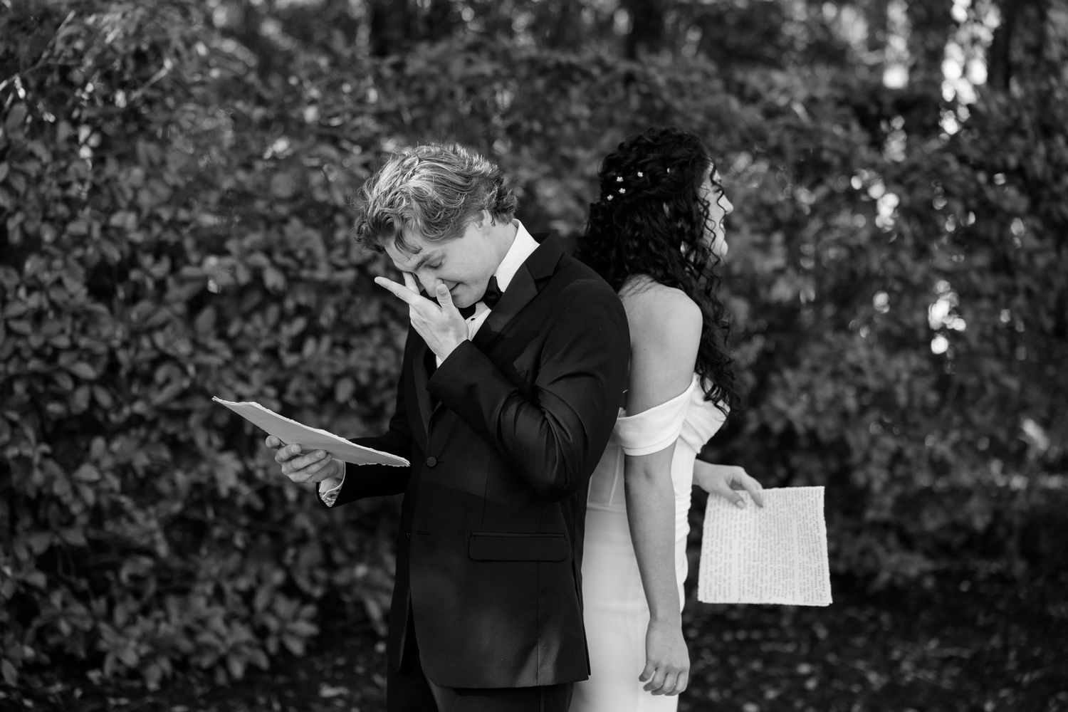Emotional black and white wedding photo of couple sharing intimate moment with written vows.