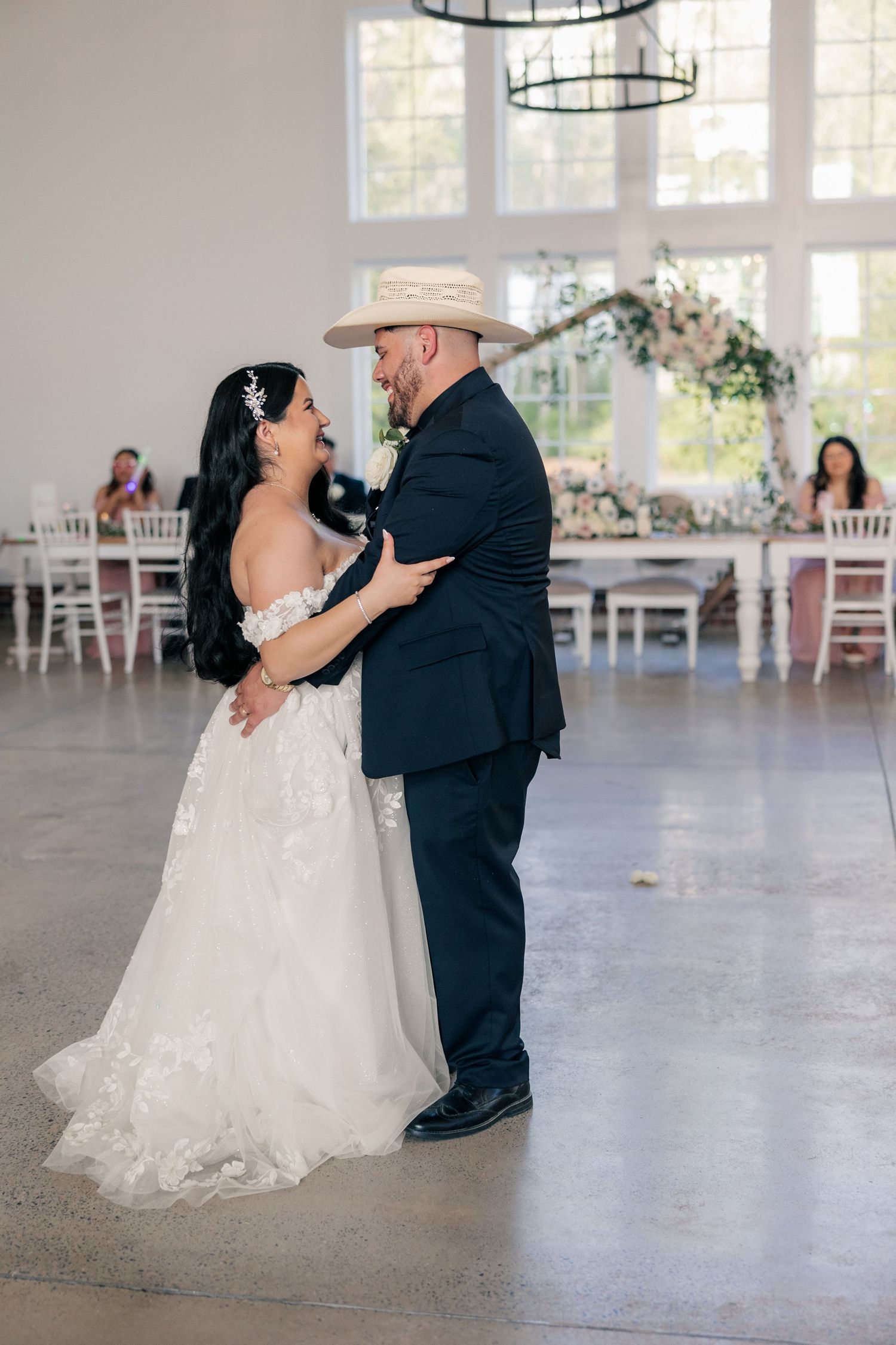 Candid dancing moments between newlyweds on a polished concrete floor at their reception.