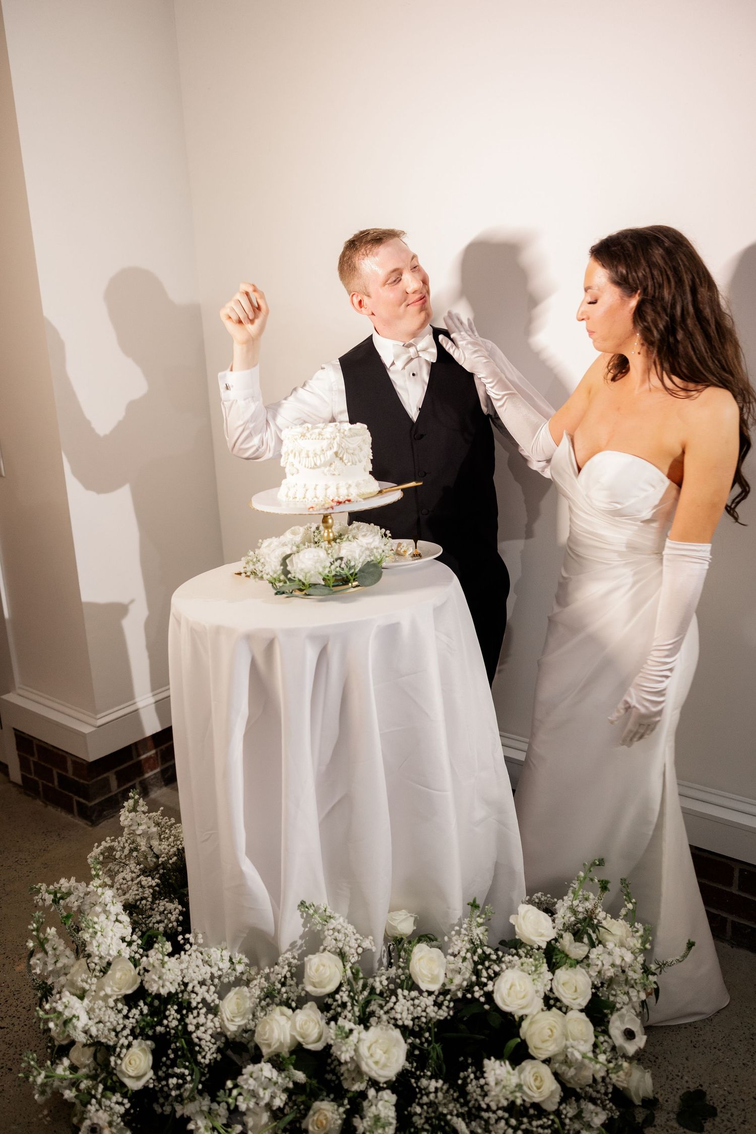 Wedding cake cutting celebration with white florals decorating the table.