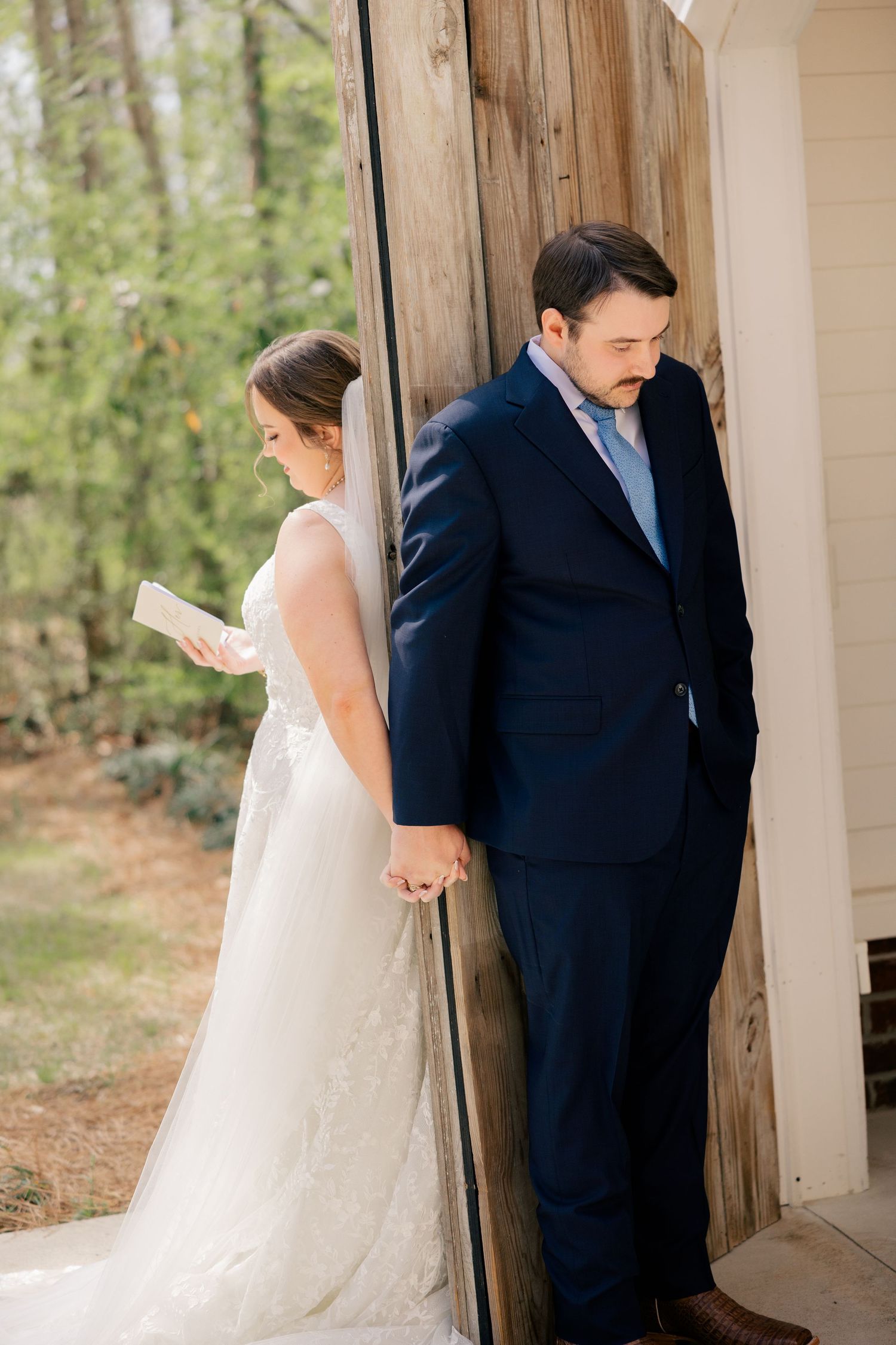 A romantic first look moment between a couple, with the bride in white and groom in navy.