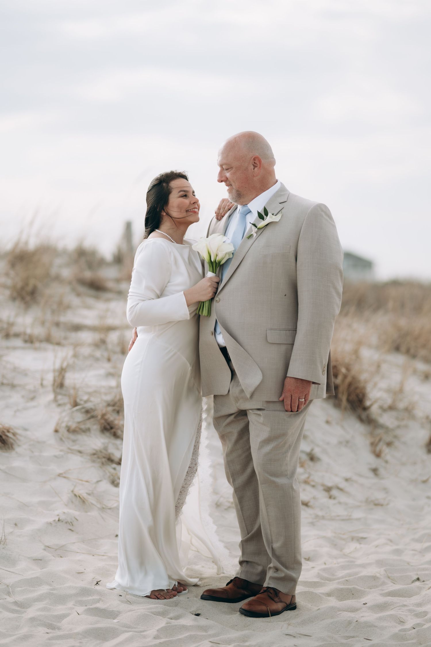 A couple in beachwear celebrates their love on sandy dunes with three romantic shots on a bright sunny day.