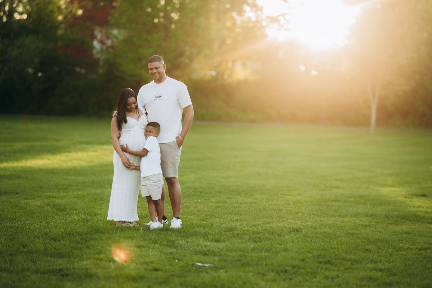 A series of dreamy sunset photos in a park showing silhouettes wearing white against a golden-lit grassy background.