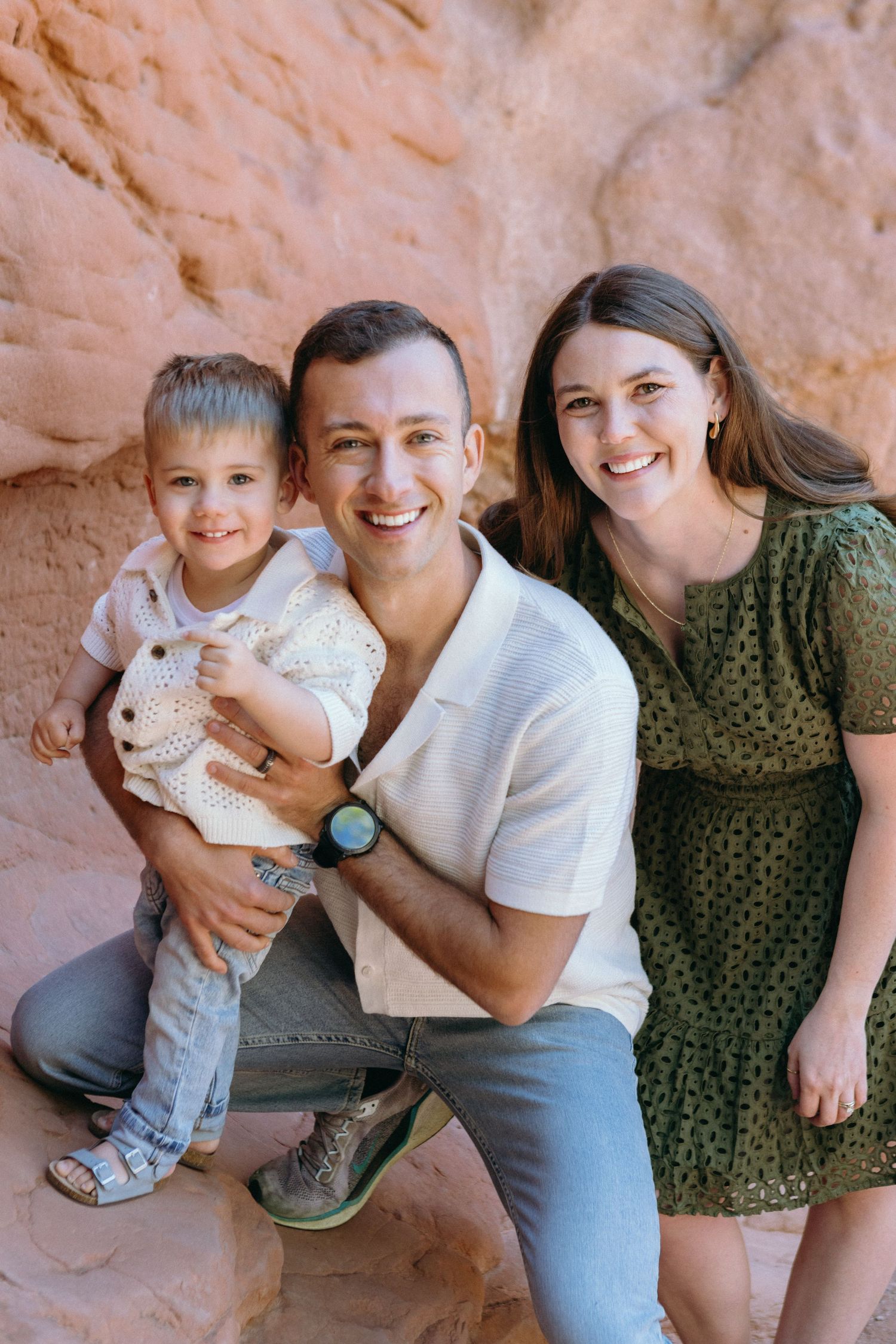 A heartwarming series of candid moments showing a family joyfully interacting and embracing together against a desert canyon wall.