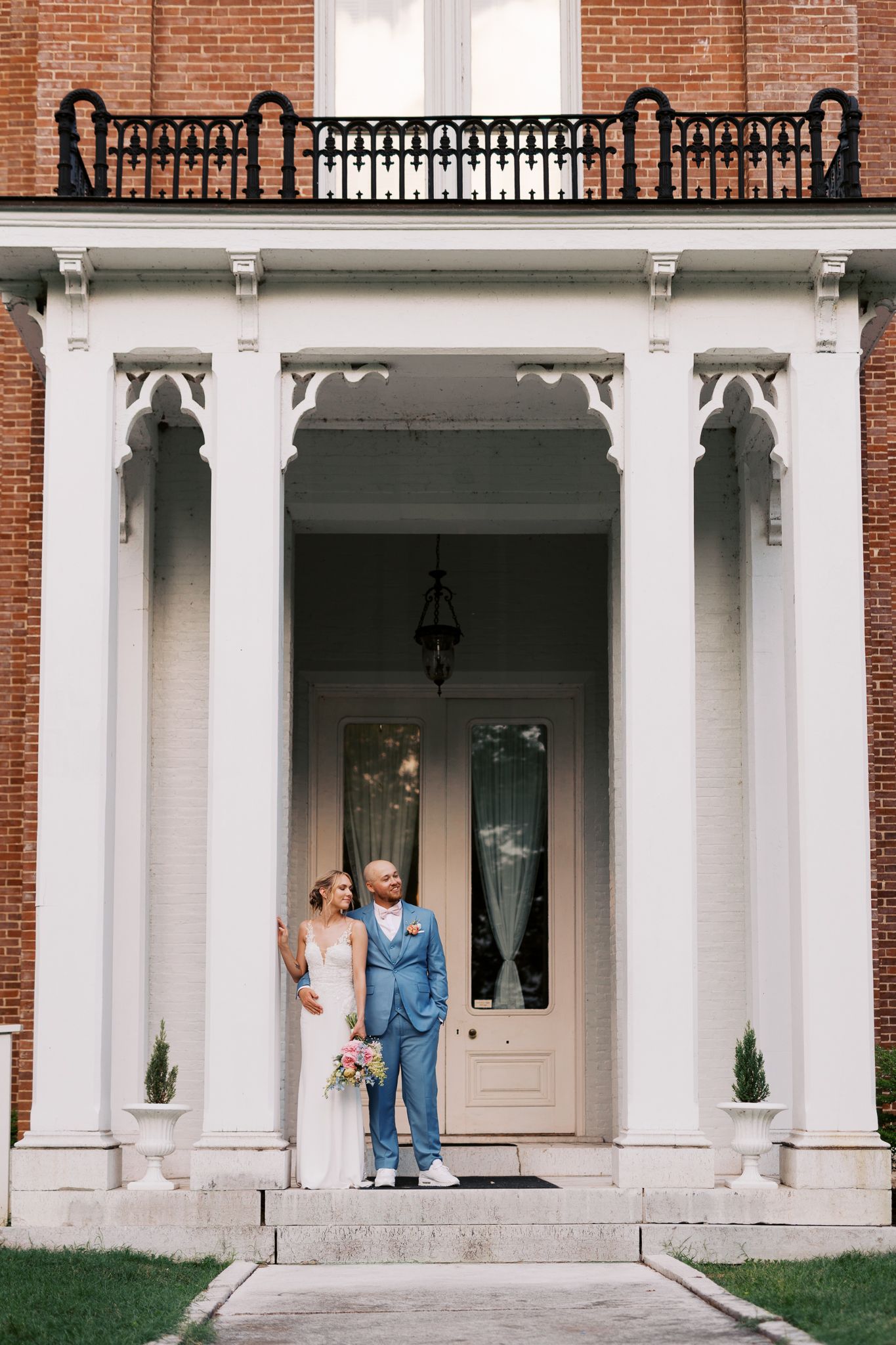 Wedding venue exterior featuring white columns and red brick architecture.