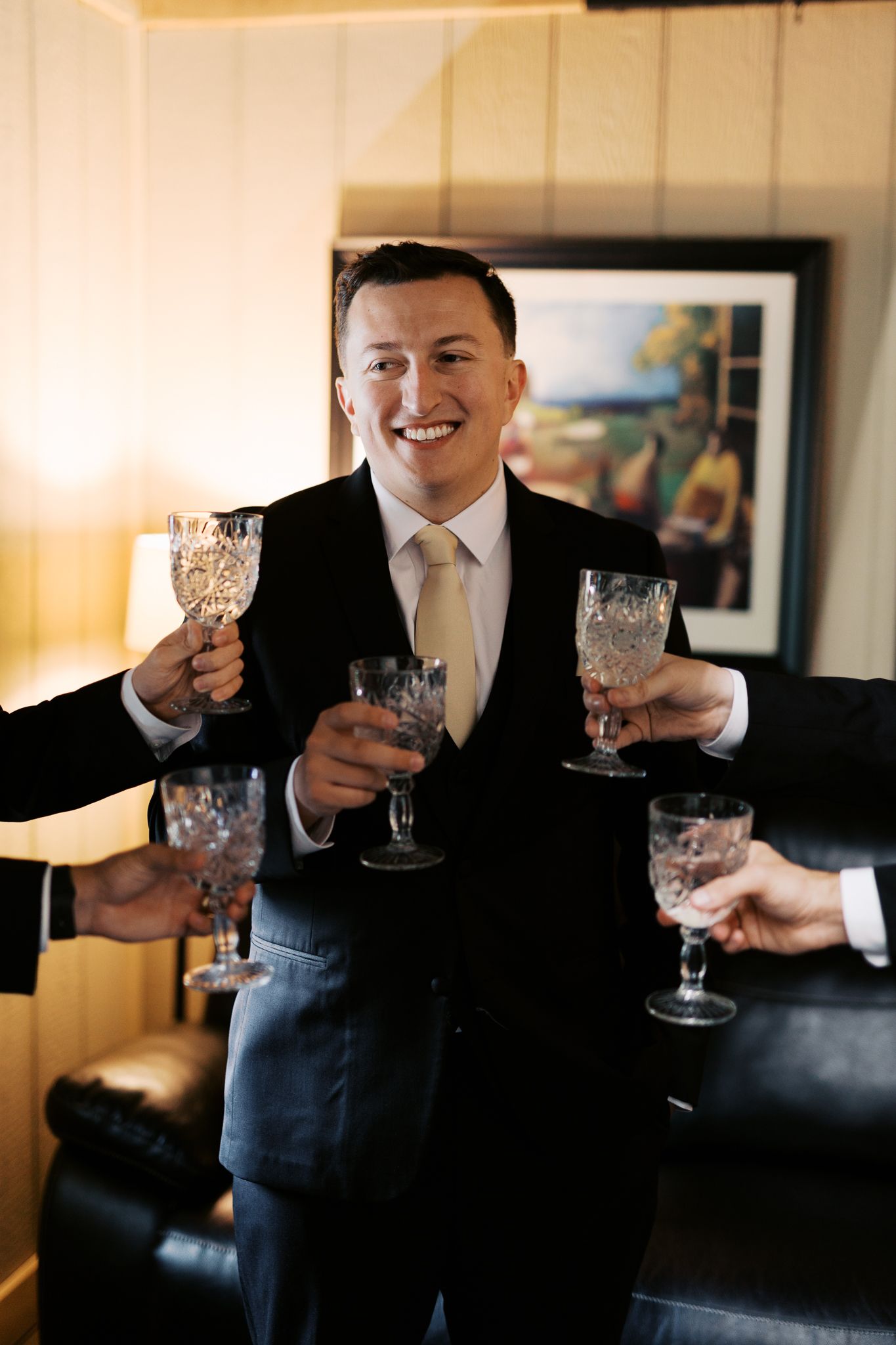Crystal glasses being held up for a celebratory toast.