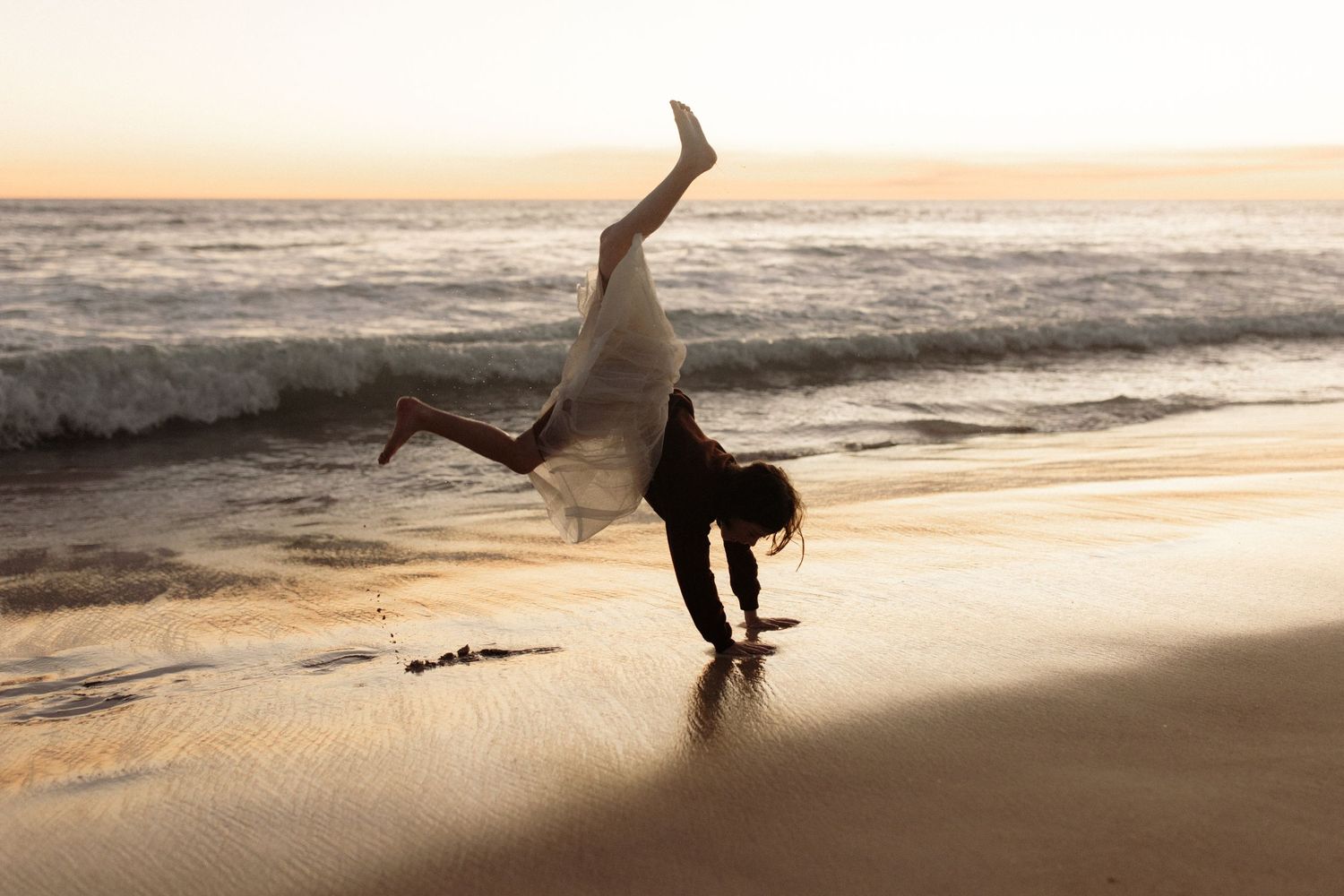 Silhouette of person doing handstand on beach at sunset. Children with ADHD
