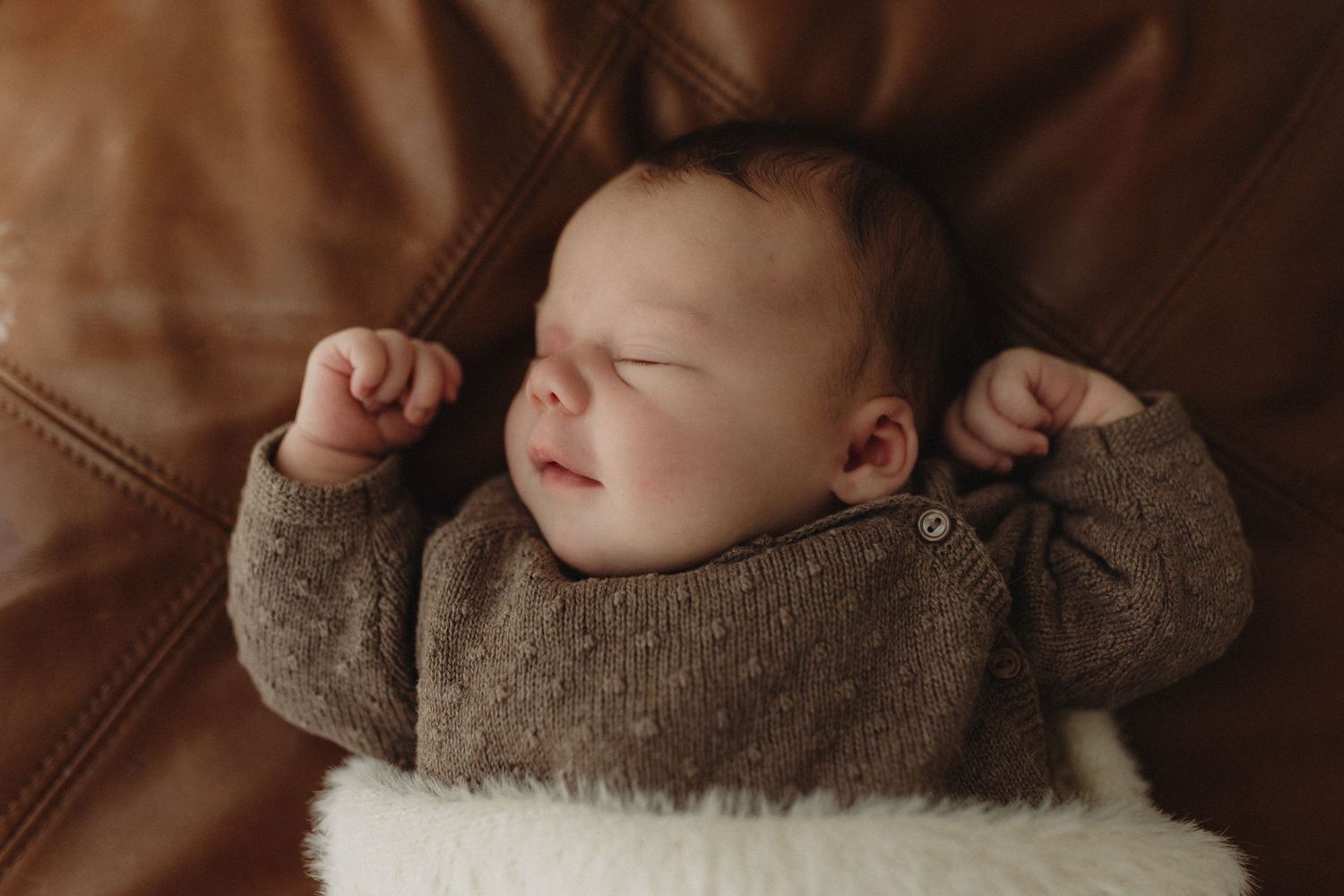 A parent and baby sharing a tender moment in muted warm tones.