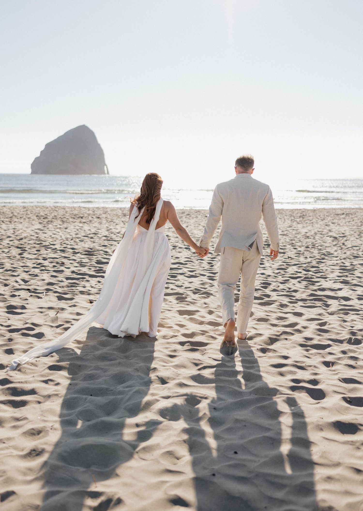 Bride and groom on beach in Oregon walking portrait