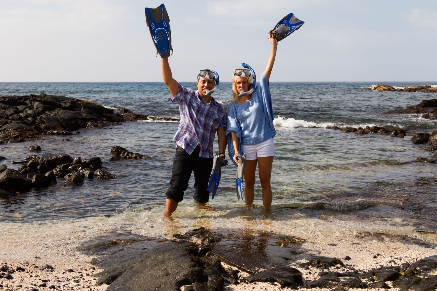 A funny engagement photo using snorkel gear in a rocky coastline during their photo session in Kailua Kona, Hawaii.