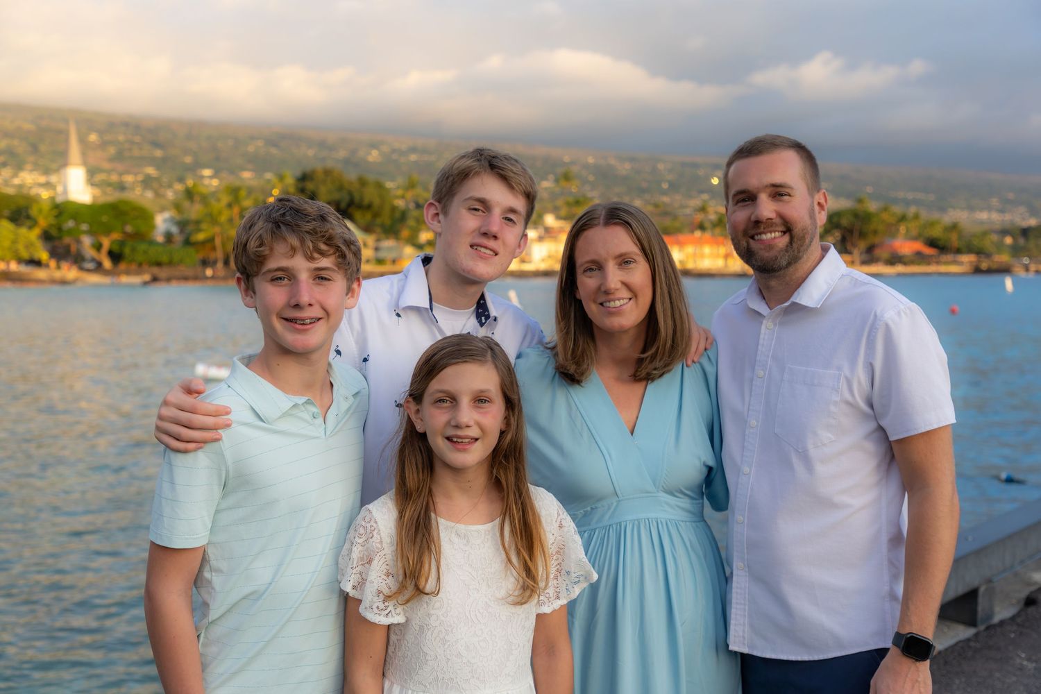 Our Kona family photographer captures a father and three pre-teen kids on the pier overlooking historic Kailua-Kona town. *