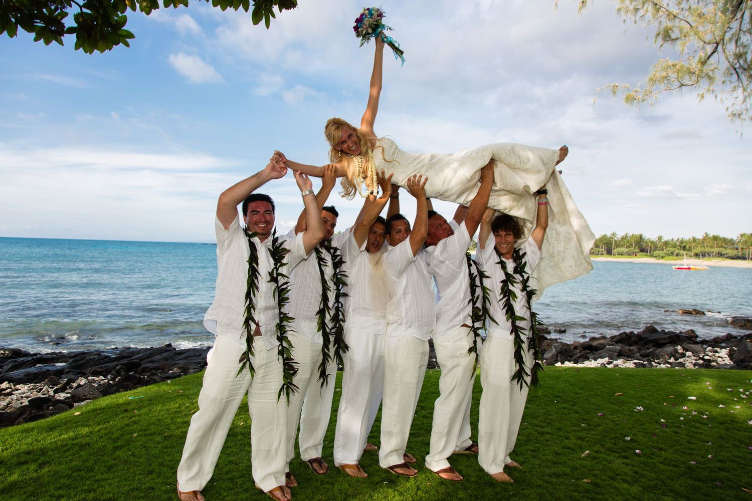A series of photos showing a beach wedding party in white attire standing together by the oceanfront in Hawaii.