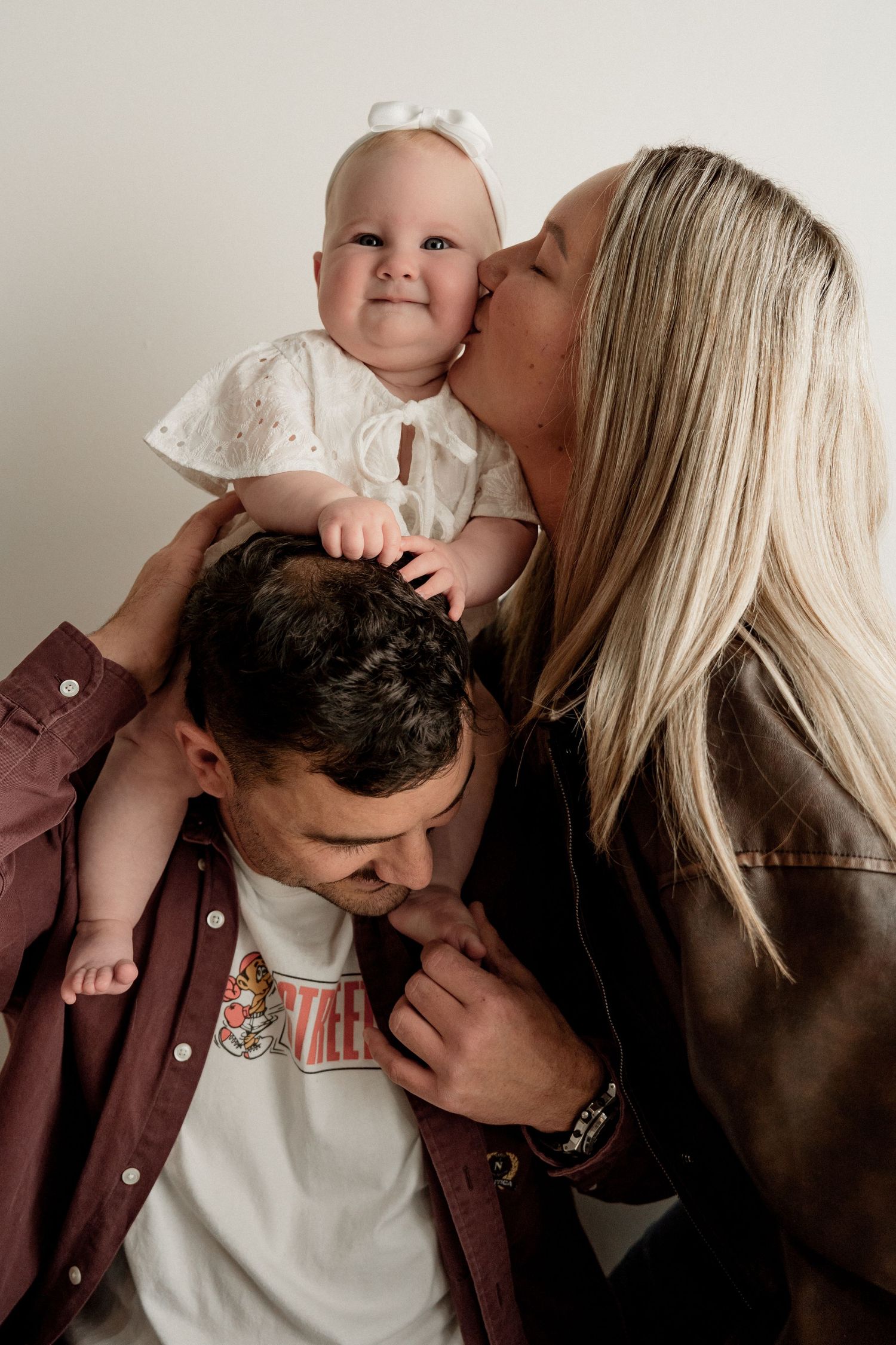 A tender family moment captured in a series of black and white photos showing affectionate embraces.