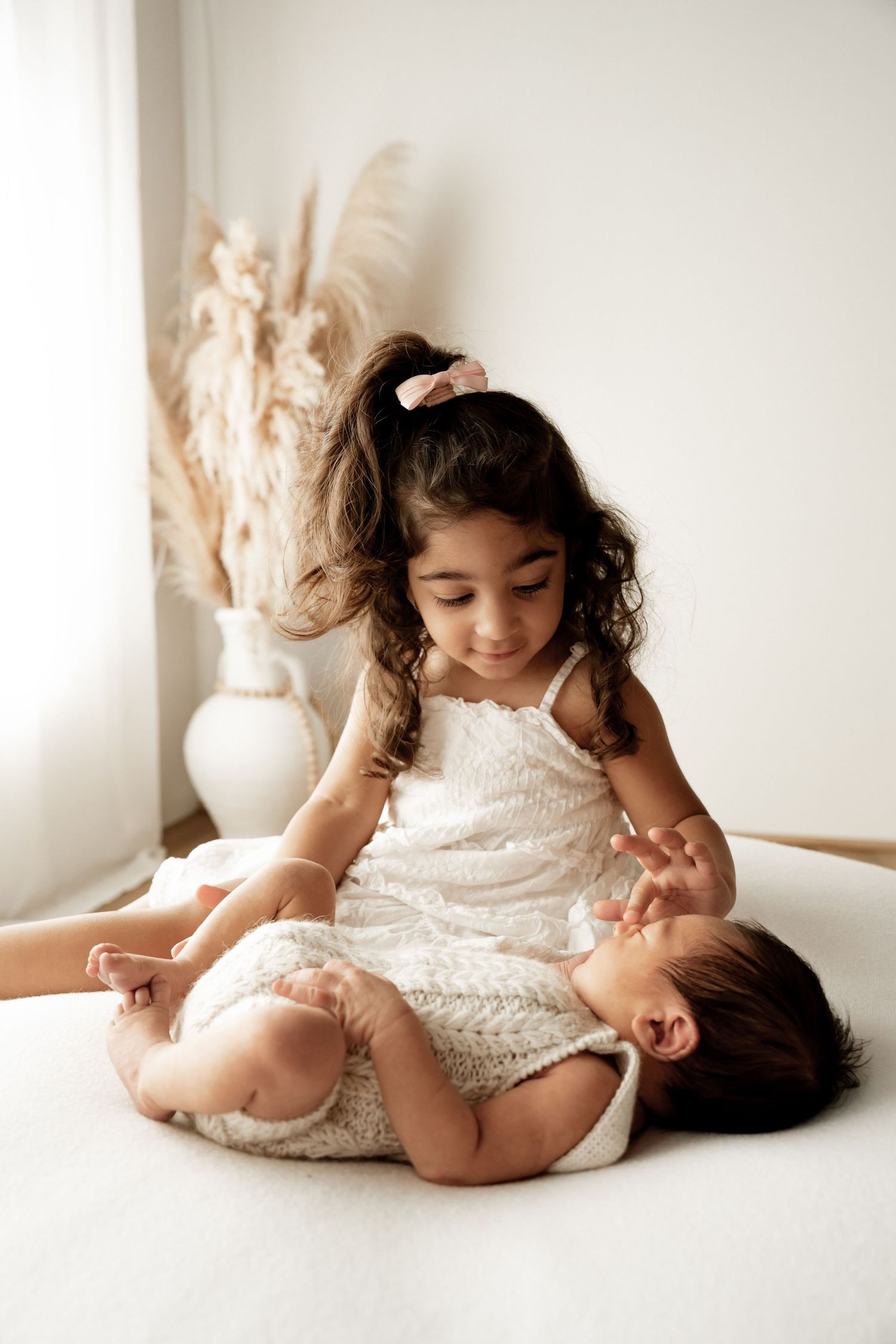 A series of photos showing a child in a white dress rolling and playing on a light colored floor.