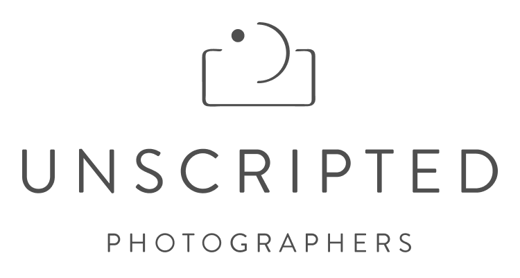 A minimalist logo design featuring a camera icon and text 'UNSCRIPTED PHOTOGRAPHERS' in clean typography.