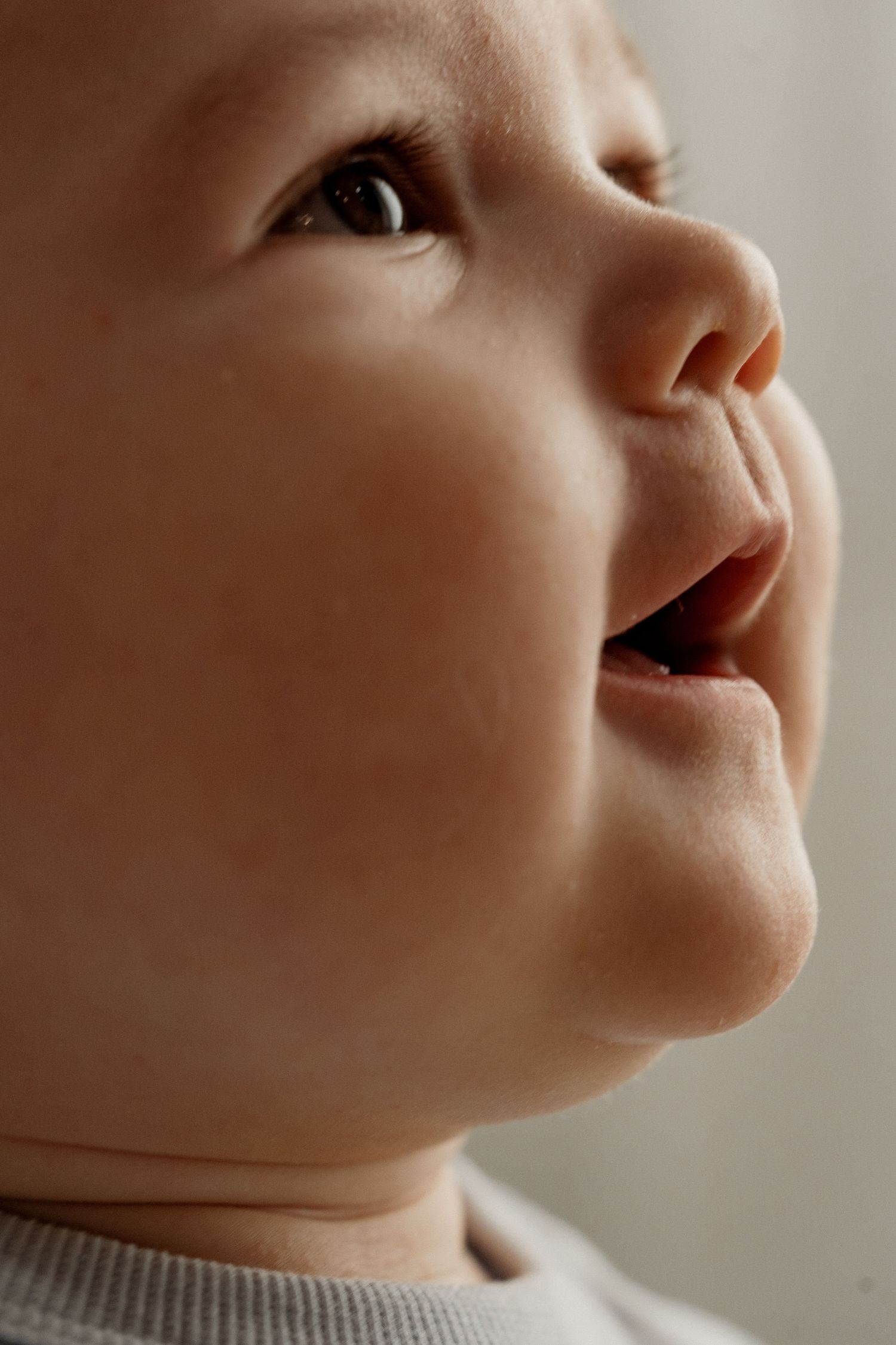 Close-up profile views of a baby's face showing different angles in warm lighting.