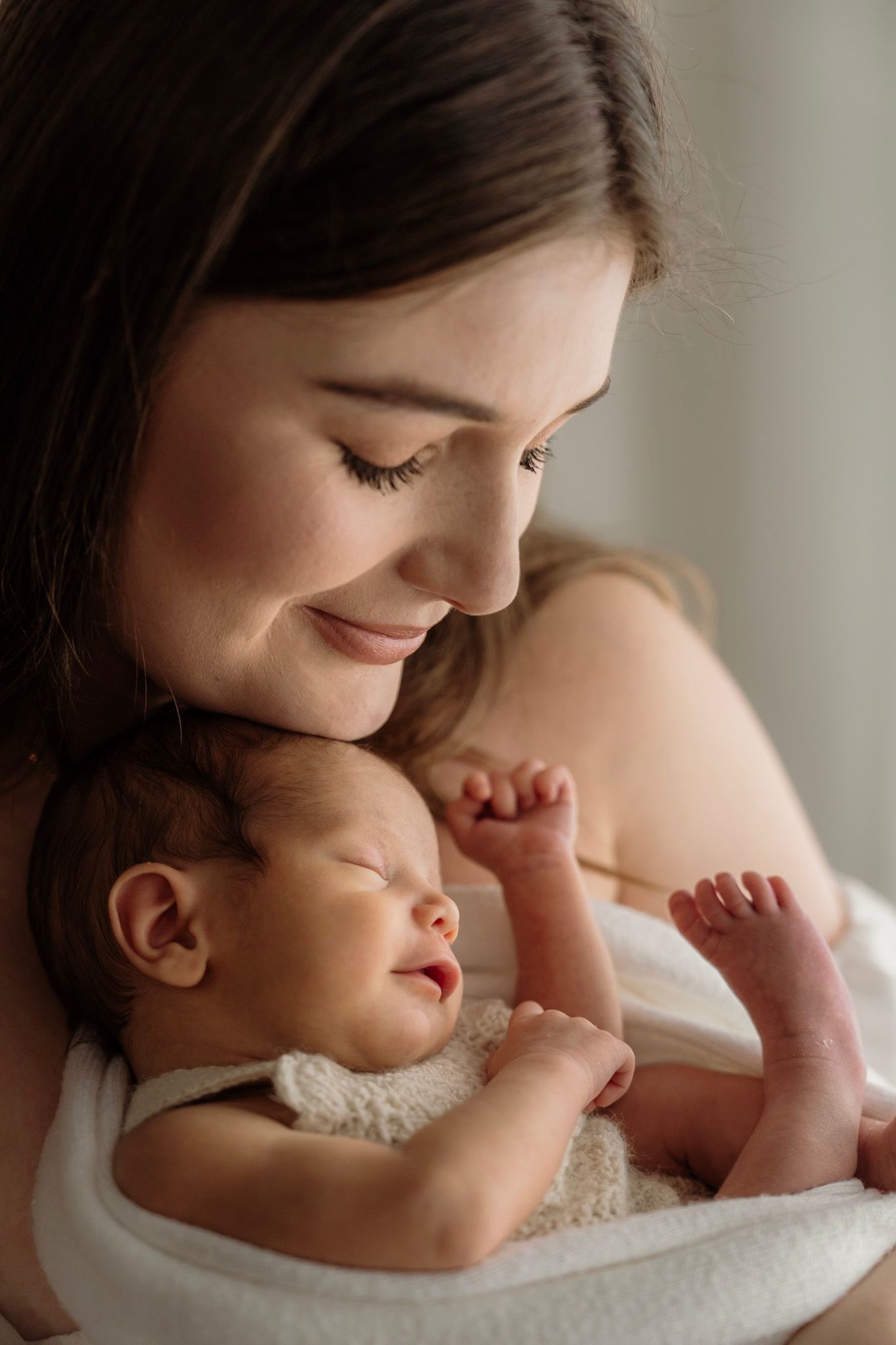 Mother and baby share a tender moment in a soft, intimate series of portrait photos showing closeness and bonding.