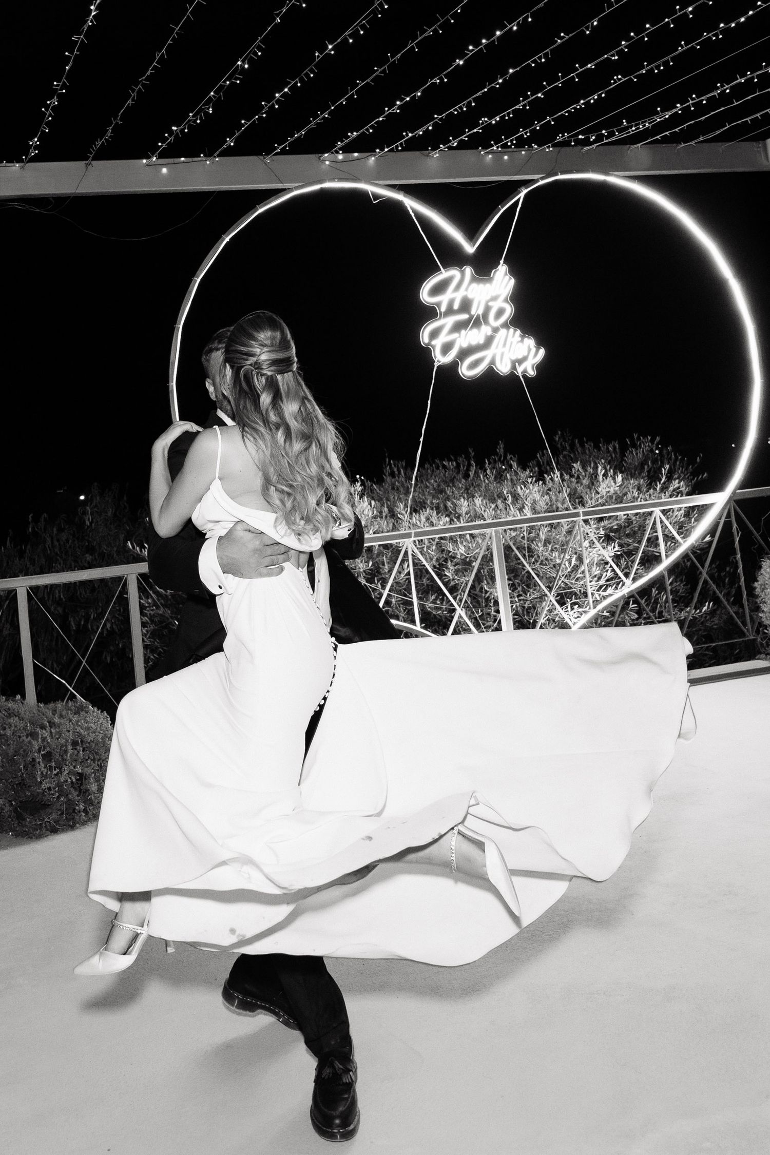 A sequence of black and white photos showing a couple in wedding attire dipping during a romantic dance at night.