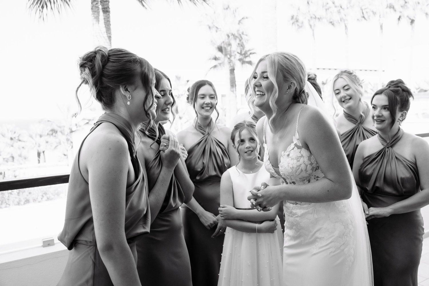 A sequence of candid black and white wedding photos showing emotional moments and reactions during a celebration.