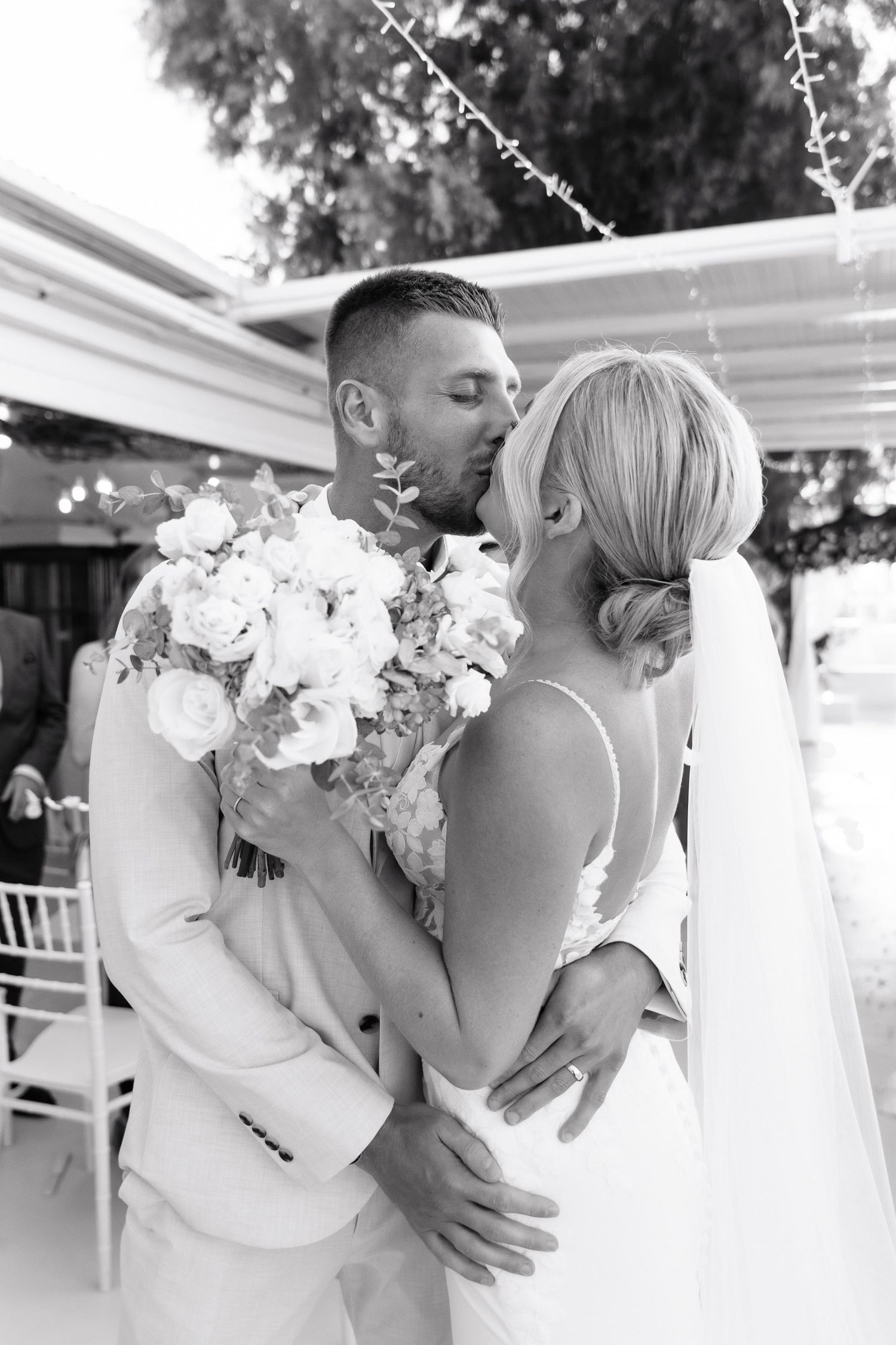 A series of romantic black and white wedding photos showing tender moments between two brides in white dresses.