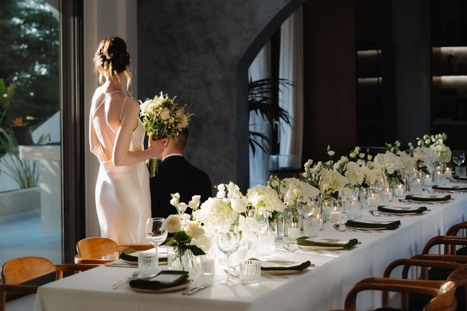 Sunlit wedding table setting with white floral arrangements and elegant place settings at Villa Borosso Rethymno, Crete