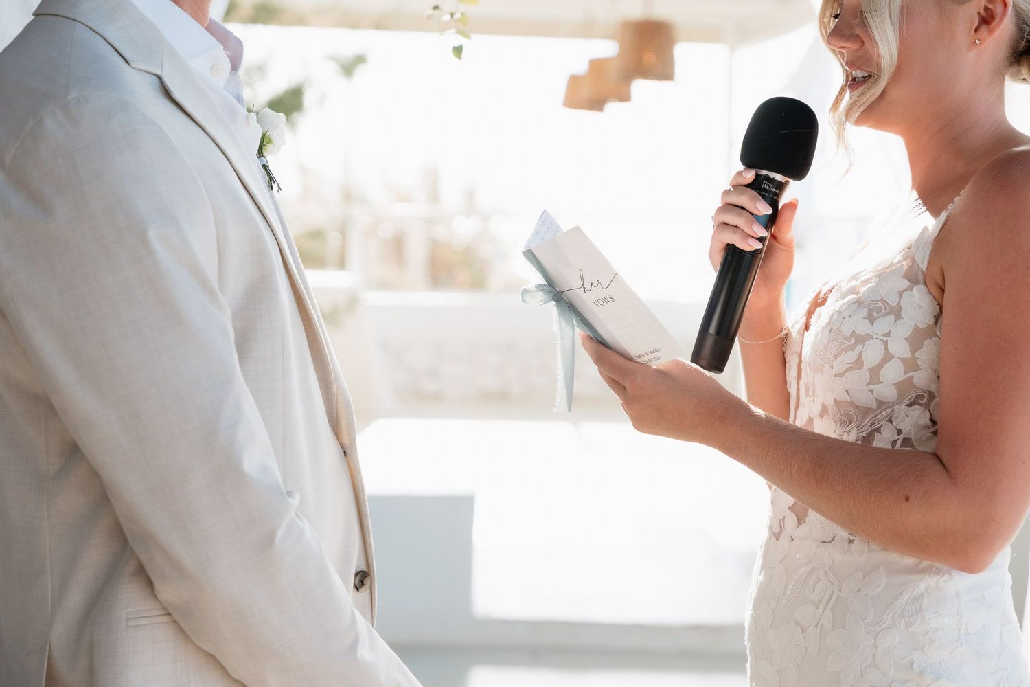 A couple shares an intimate moment during their wedding ceremony while holding microphones.