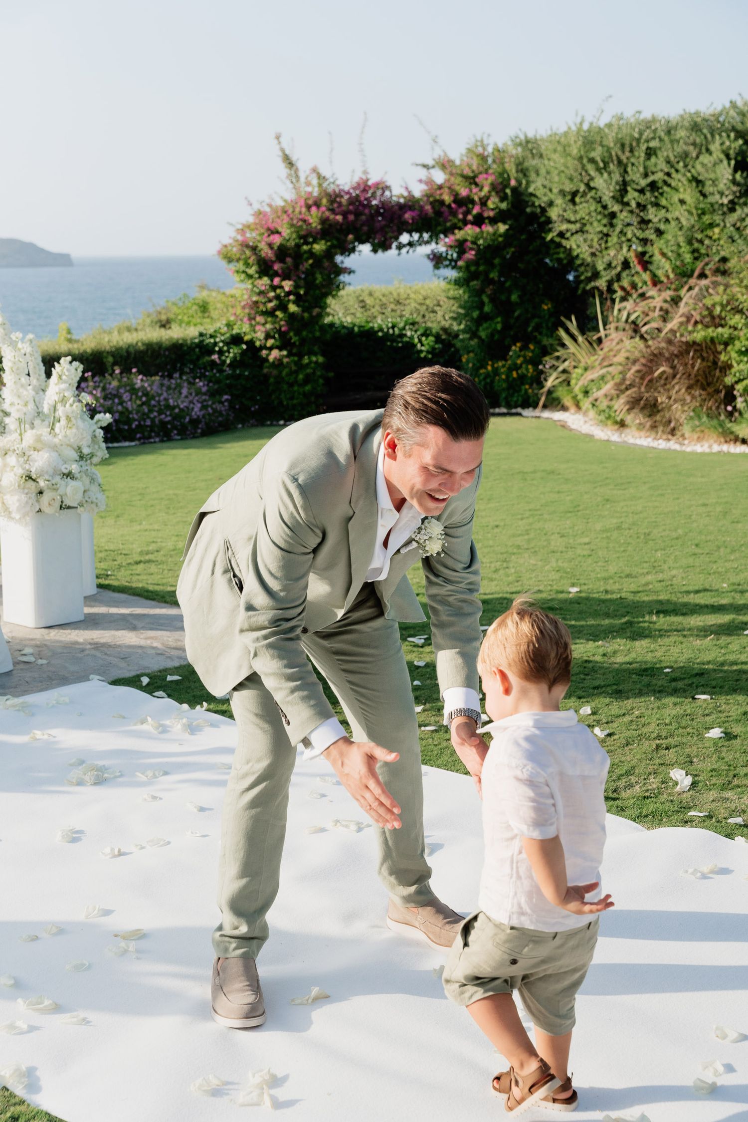 A sweet moment captured in a sequence of three photos showing playful interaction on a grassy oceanside lawn.